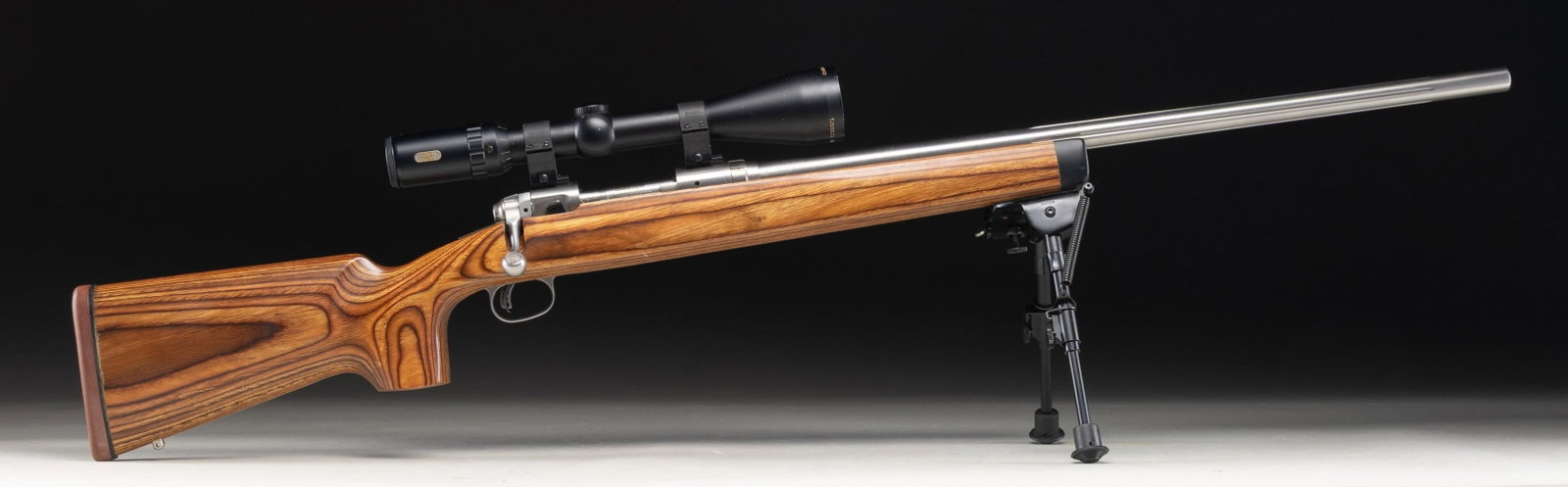 SAVAGE MODEL 12 BOLT ACTION RIFLE.: Cal. 223 Rem. S# G198813. Bbl. 26" fluted heavy. Rifle is sighted with a Tasco Titan 3-12x52. Scope has crosshair reticle & very good optics. Stainless finish. Accu-Trigger. Laminated stock set with u