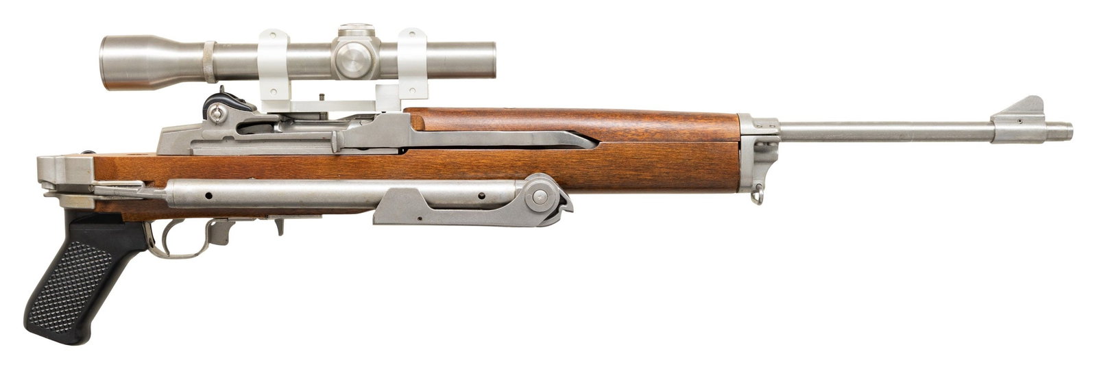 EARLY STAINLESS RUGER MINI-14 SEMI-AUTO CARBINE: WITH FACTORY FOLDING STOCK. Cal. 223 Rem. S# 182-29142. Bbl. 18 1/2" with barrel band having integral serrated ramped blade front sight; military style adjustable receiver sight at rear of action. Mfg