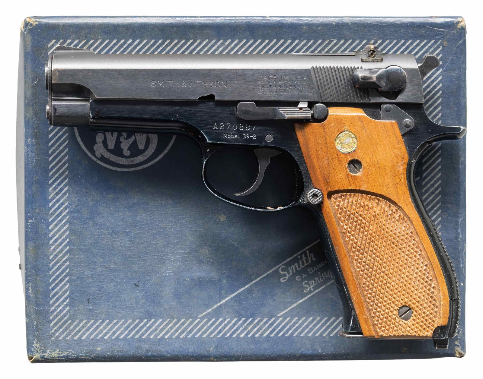 SMITH & WESSON MODEL 39-2 SEMI AUTO PISTOL.: Cal. 9mm Luger. S# A279887. Bbl 4". Ramped serrated blade front sight. Square notch rear sight. 1975-1976 made 39-2 pistol. Blued slide & anodized frame. Checkered walnut grips with silver S&W medalli