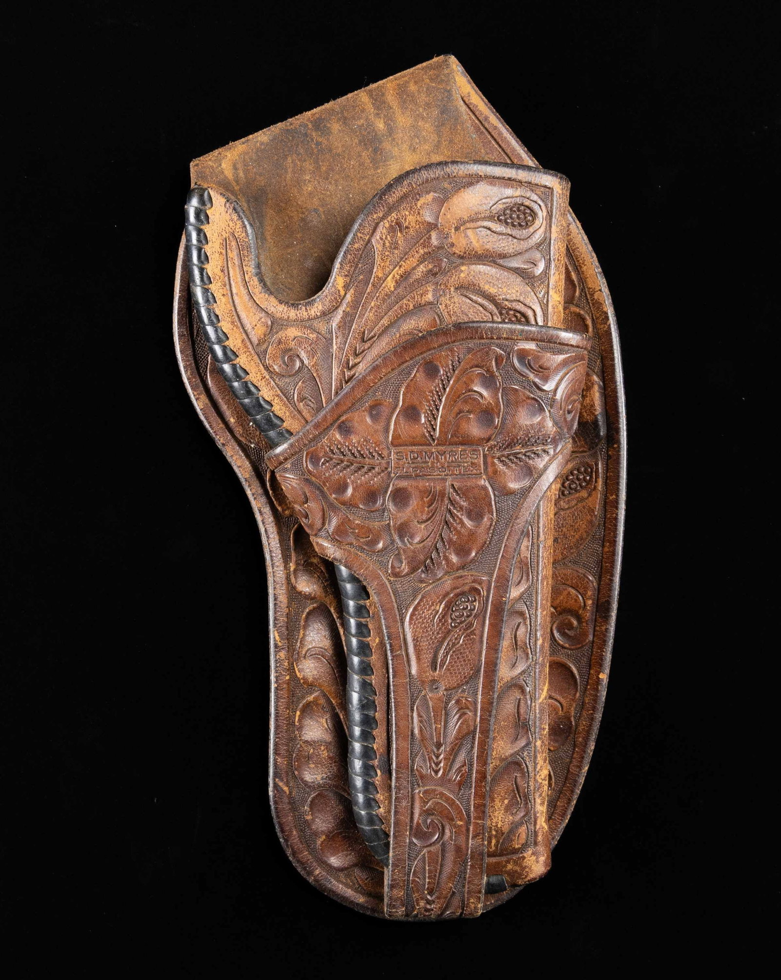 S.D. MYRES TOOLED LEATHER COLT SINGLE ACTION ARMY: REVOLVER HOLSTER. Brown leather holster produced by S.D. Myres of El Paso, TX for a Colt Single Action Army revolver with a 4 3/4" bbl. Holster features decorative floral tooling on a matte