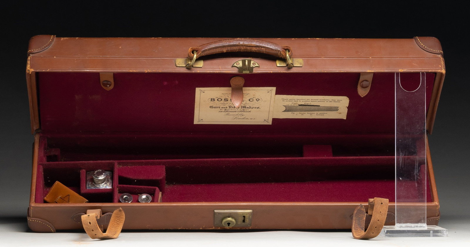 BOSS & CO. DOUBLE SHOTGUN LUGGAGE CASE.: Brown leather case measures approx. 27" x 7" x 6". Can fit 25" barrels. Case contains 2 sets of 12 Ga. snap caps, oil bottle, cleaning kit & key. CONDITION. case appears in good condition with