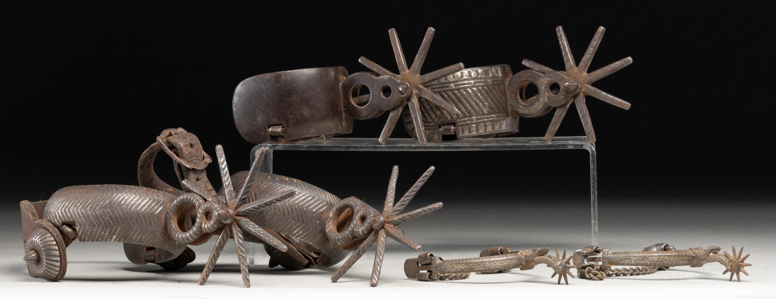 THREE GOOD PAIR OF SPANISH COLONIAL SPURS.: Two pair of matching heavy style with massive rowels used in Texas, Mexico in 19th century, later smaller pair popularized mid-19th century and still worn today. CONDITION: very good overall, iron pat