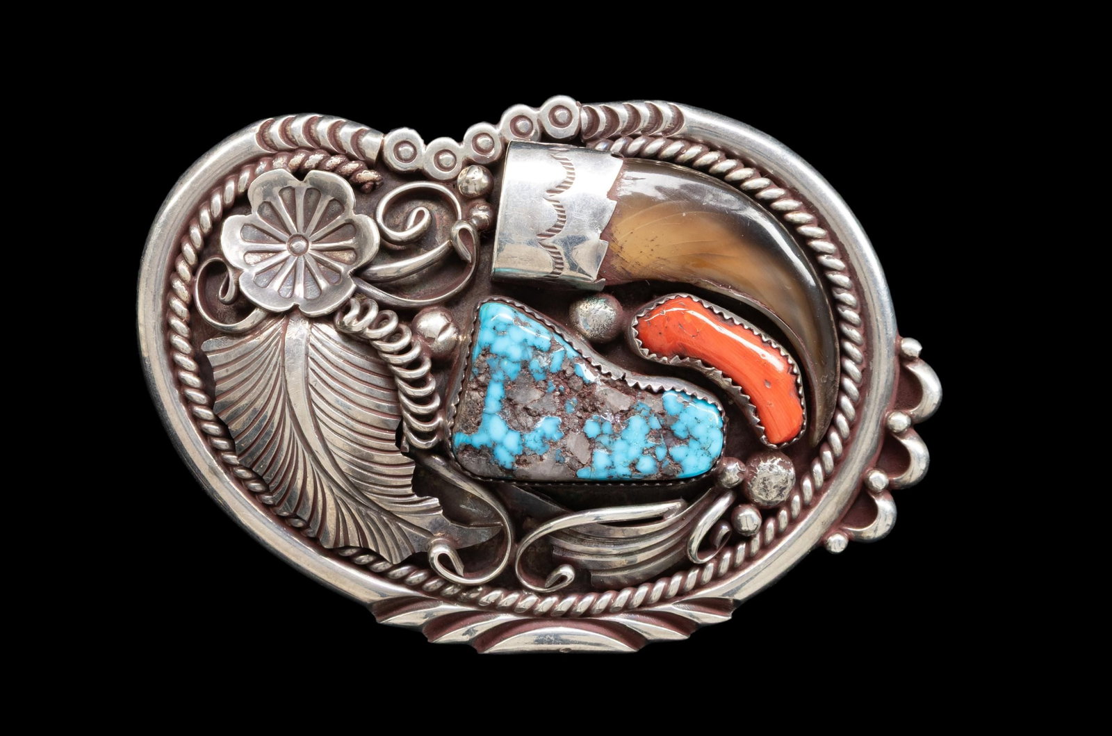 "TOM DINETSO" SIGNED SILVER NAVAJO TURQUOISE &: BEAR CLAW BELT BUCKLE. 3.5" x 2.5" sculpted oval buckle with fine silver, turquoise, red coral, and bear claw decoration. 74 grams. CONDITION: good. (02-27020-1/JS). NON-GUN. $200-400.