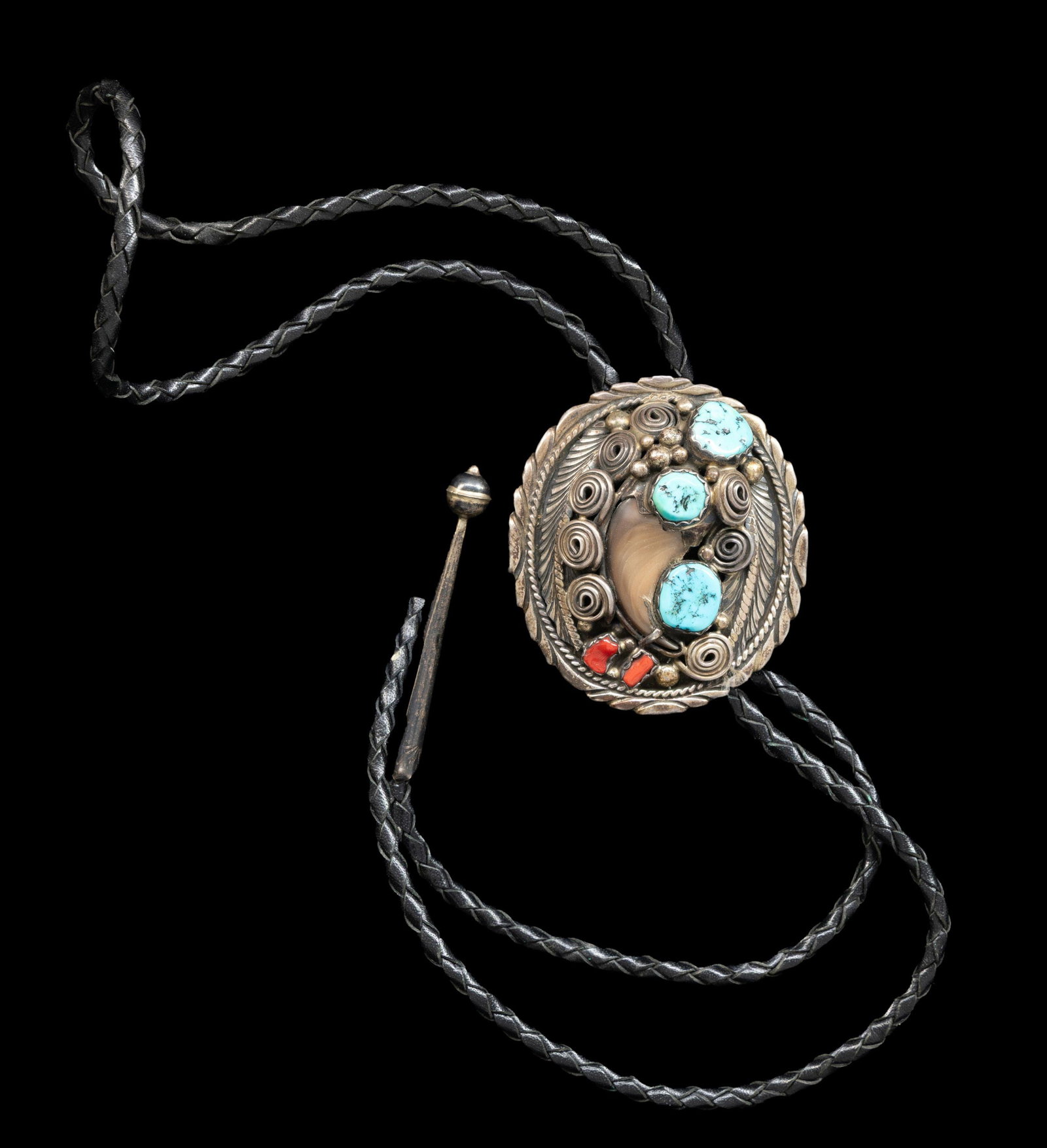 "PERCY SPENCER" SIGNED STERLING NAVAJO TURQUOISE,: RED CORAL & BEAR CLAW BOLO. 2.25" x 2" sterling bolo drop with turquoise, red coral, and bear claw decoration, woven leather bolo with silver tips, 60 grams. CONDITION: good. (02-27023-4/JS). NON-GUN.