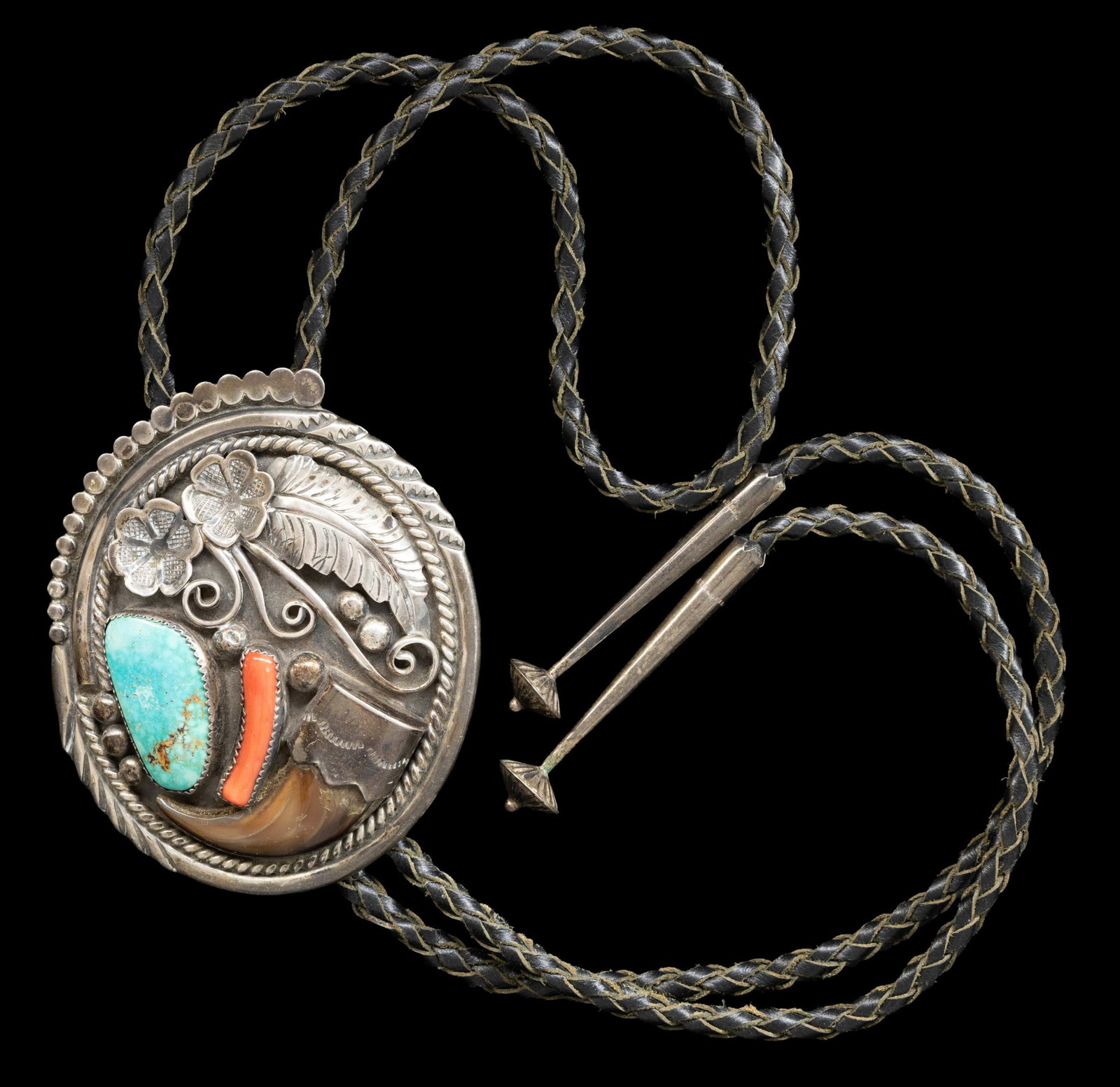 VINTAGE SILVER "TOM DAVID" SIGNED NAVAJO TURQUOISE: & BEAR CLAW BOLO. 3" x 2.5" turquoise and bear claw decoration, woven leather bolo with silver tips, signed with Tom David's early "TD" logo, total weight 82 grams. CONDITION: good. (02-27025-1/JS). N
