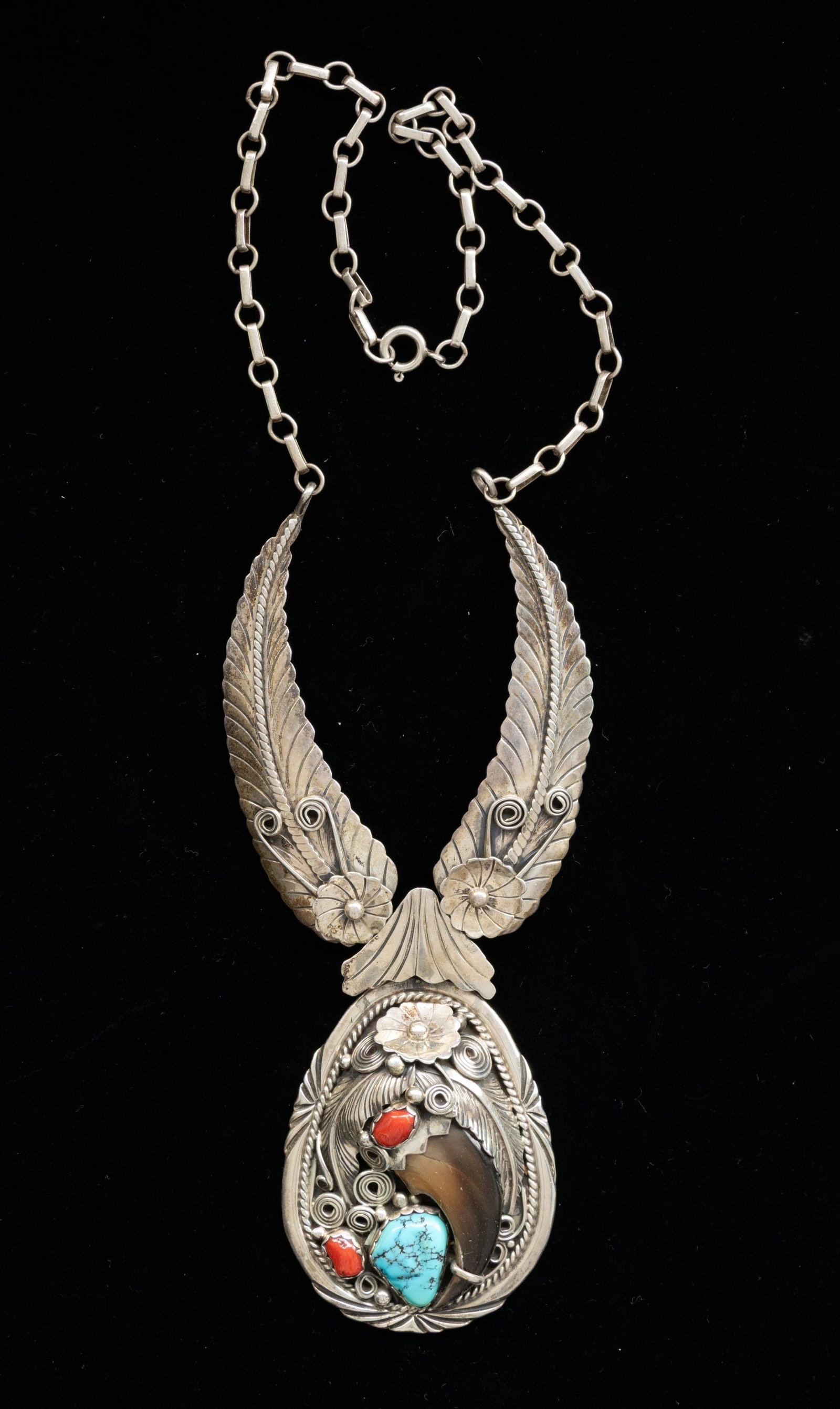 "PERCY SPENCER" SIGNED STERLING SILVER NAVAJO: TURQUOISE & BEAR CLAW NECKLACE. 20" silver looped necklace with 2 wings and 2.5" red coral, bear claw, & turquoise drop signed "PERCY SPENCER / STERLING", 55 grams. CONDITION: good. (02-27028-4/JS). N