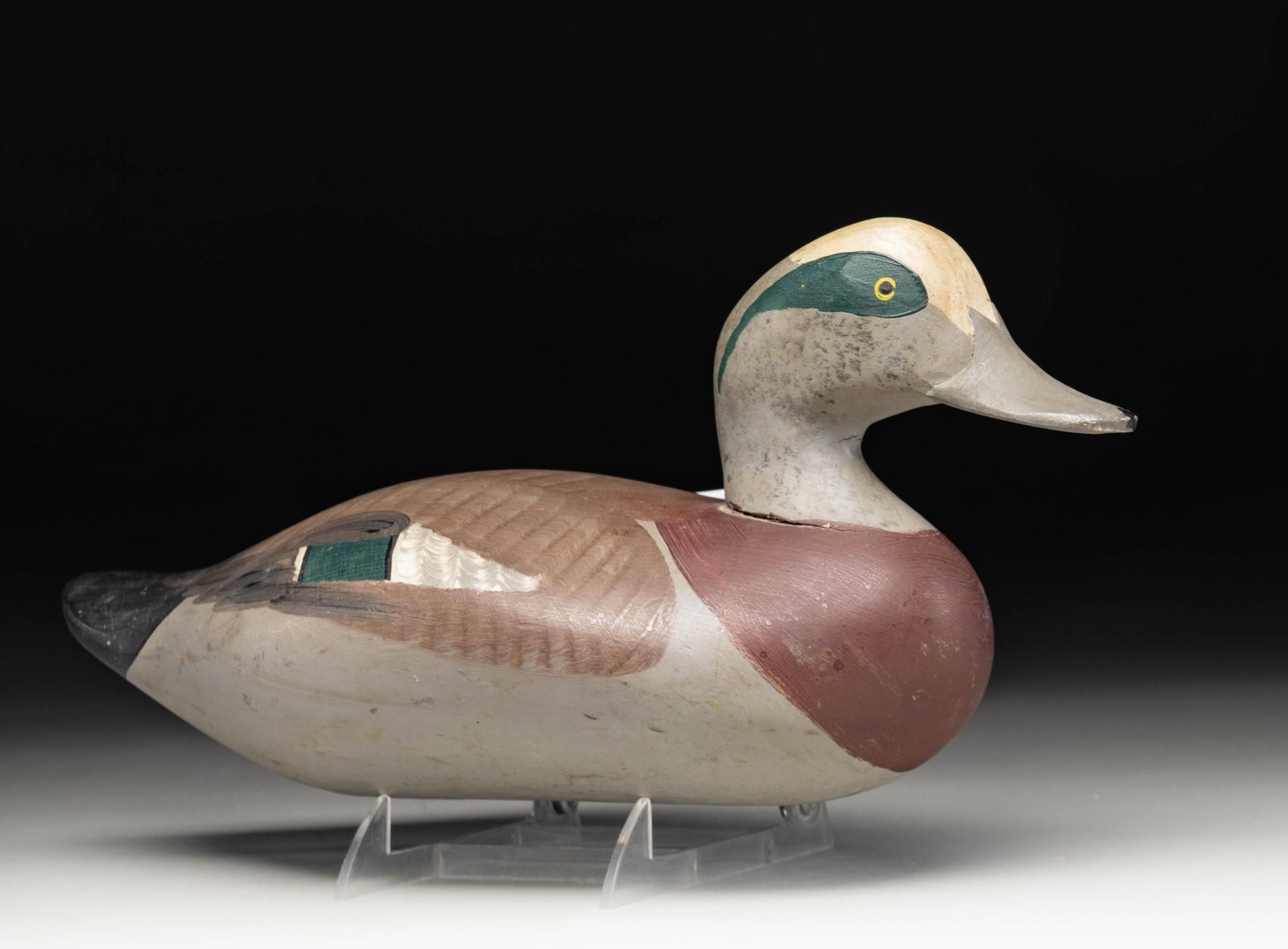 R. MADISON MITCHELL, WIGEON DRAKE DECOY.: Wigeon drake decoy crafted by R. Madison Mitchell. Decoy measures approx. 15" in length, featuring brown, gray, green, and black plumage, with a gray bill and painted yellow eyes. Underside of bill is