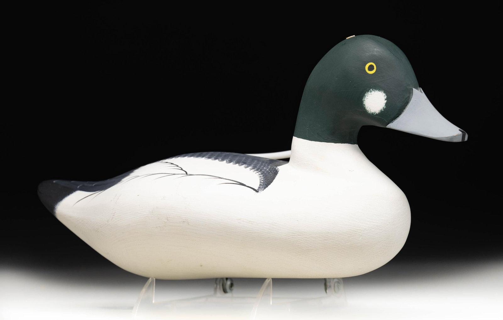 "MJH" SIGNED GOLDENEYE DRAKE DUCK DECOY.: Goldeneye drake duck decoy crafted by an unidentified maker. Decoy measures approx. 14" in length, and features white, black, and green plumage with a gray bill and painted yellow eyes. Underside of d