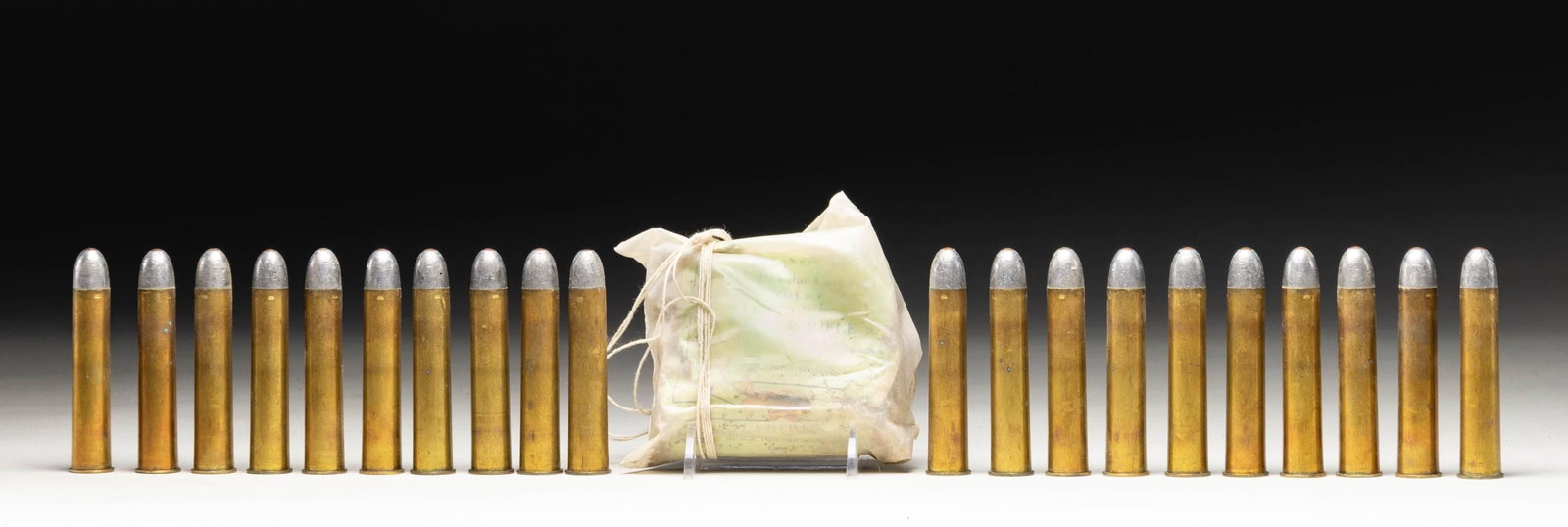 GROUPING OF VINTAGE KYNOCH 577 NITRO EXPRESS: CARTRIDGES. Cartridges with their 3" brass cases are headstamped "KYNOCH / 577". Lead round nose bullets with copper tips. 30 loaded rounds. 10 rounds are in a deteriorated green labeled paper package