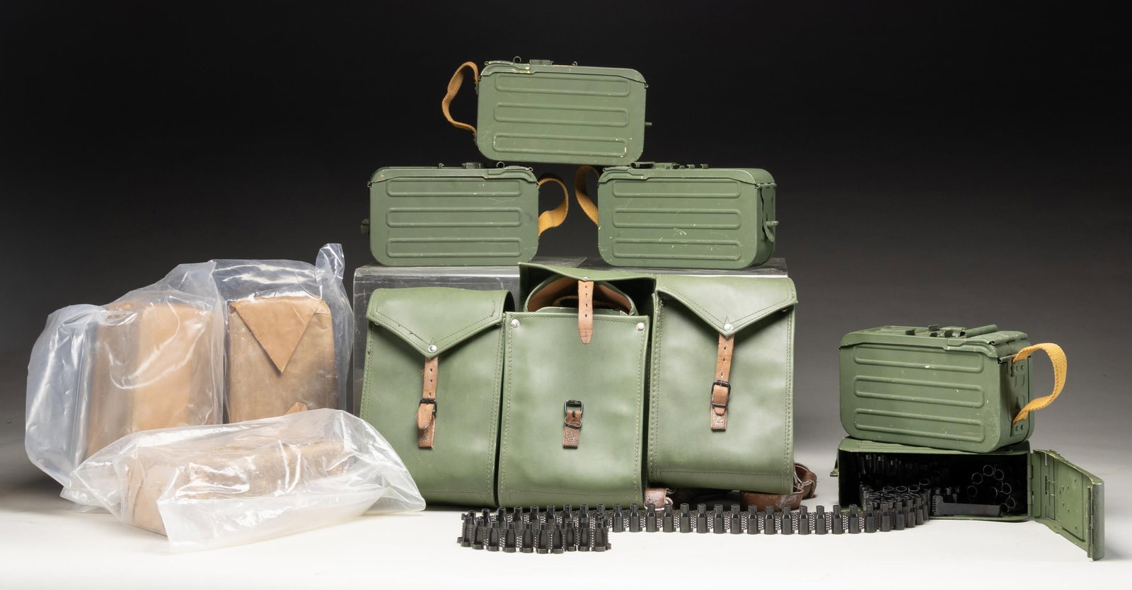 LOT OF 11 PKM DRUMS & LINKS.: This lot consists of the following: 1) Eleven PKM 100 rd. drums. 2) Three drum pouches. 3) Approx 200 metal links. CONDITION: three drums are sealed in wax wrapping. Others show moderate storage/surpl
