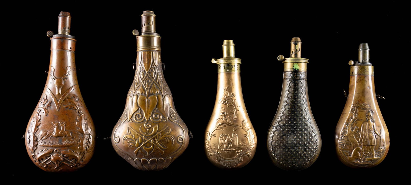 FINE GROUP OF 5 DECORATED ANTEBELLUM POWDER FLASKS: . This group has some very interesting designs including 10" Riling 581 with motif of Indian shooting buffalo on horseback; 9.50" Riling 670 violin shape with panoply of hunting arms; 8" Riling 799 ea