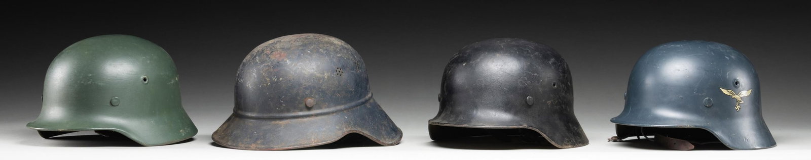 4 WWII GERMAN HELMETS.: 1) WWII German M1940 Wehrmacht helmet with a green repainted finish and no decals. The inside rear is stamped " 5082 " and on the inside left " Q64 " indicating manufacture by Quist of Esslington. Bro