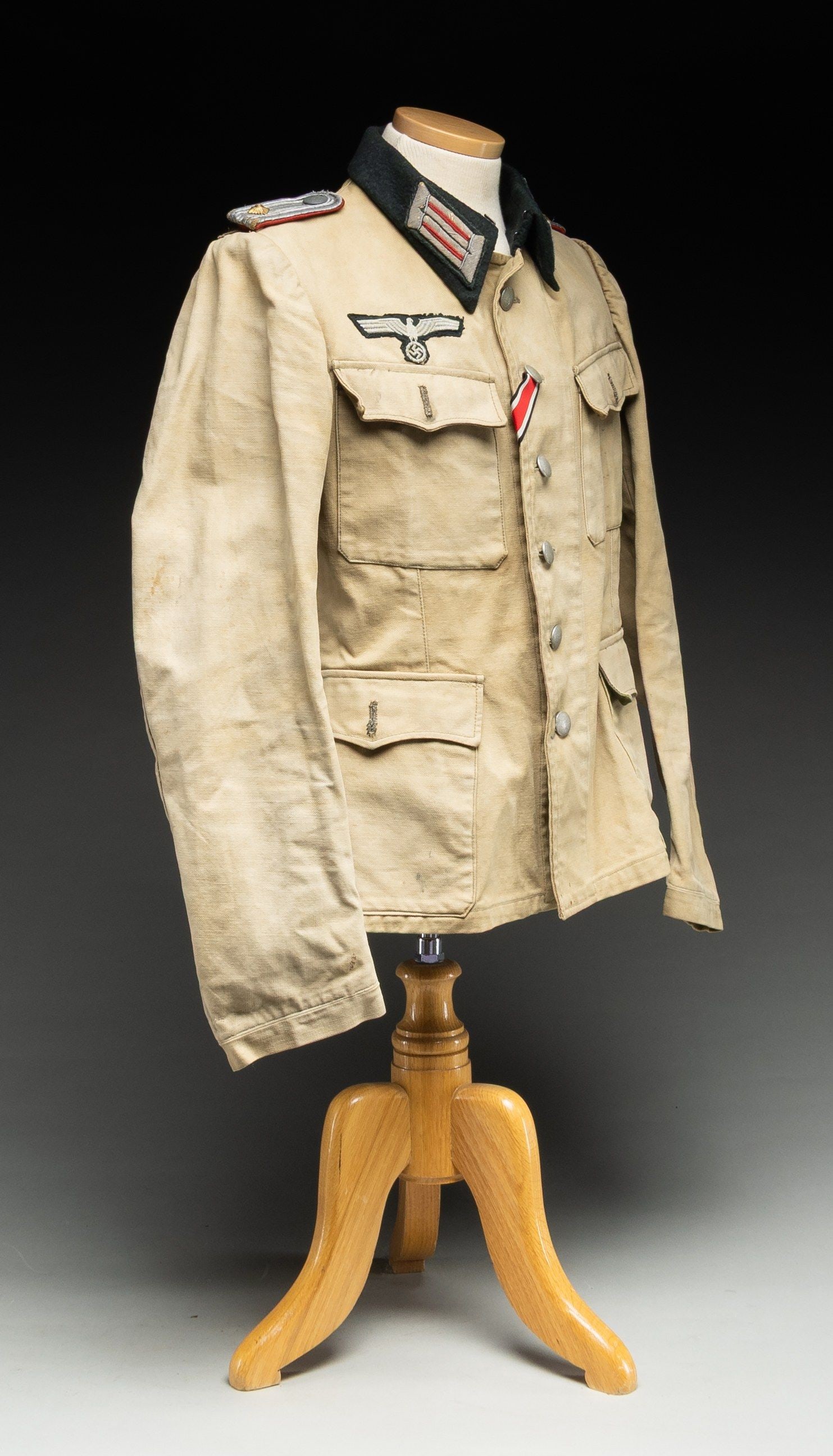 GERMAN ARMY SUMMER WEIGHT TUNIC FOR ARTILLERY.: WWII German summer weight tunic for a 1st lieutenant of Artillery. The tunic has a tan canvas body with a six button front and 4 flap pockets. The flaps for the bottom two pockets have an olive drab b