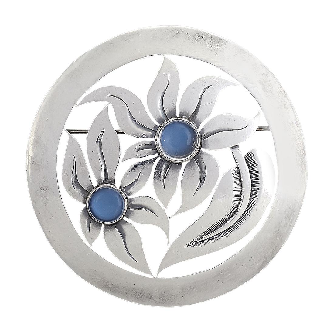 Madeleine Turner floral brooch with moonstones: Madeleine Turner (b. 1905) round brooch, #5198 New York, New York sterling silver, moonstones stamped marks pierced with two flowers centered by round cabochon stones 1 15/16"dia Provenance: The Paul 