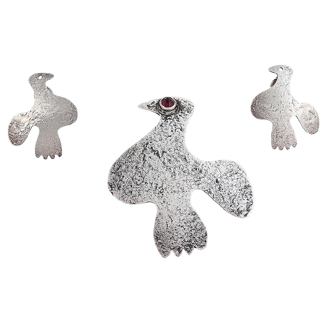 Ed Levin Bird brooch and earrings demi-parure: Ed Levin (1921-2008) Bird ladies demi-parure: brooch and post earrings Bennington, Vermont sterling silver, garnet stamped marks with an original Ed Levin box brooch: 1 11/16"w x 2"h Provenance: The P