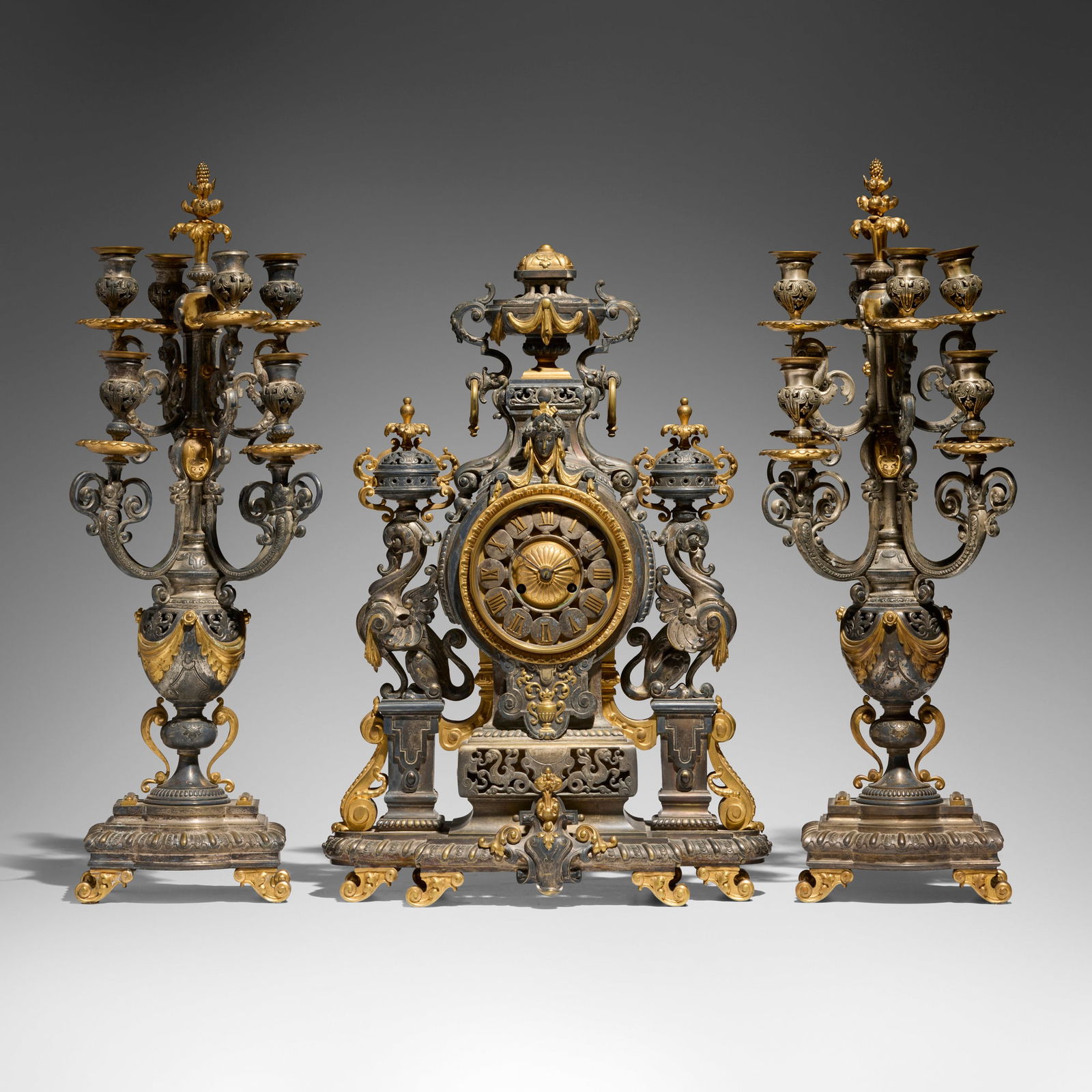 French, retailed by Tiffany & Co., Napoleon III clock garniture set: French, retailed by Tiffany & Co. Napoleon III clock garniture set 19th centurysilvered and gilt bronze 26.75 h x 9.5 w x 9 d in (68 x 24 x 23 cm) 24 h x 16.5 w x 8.5 d in (61 x 42 x 22 cm)