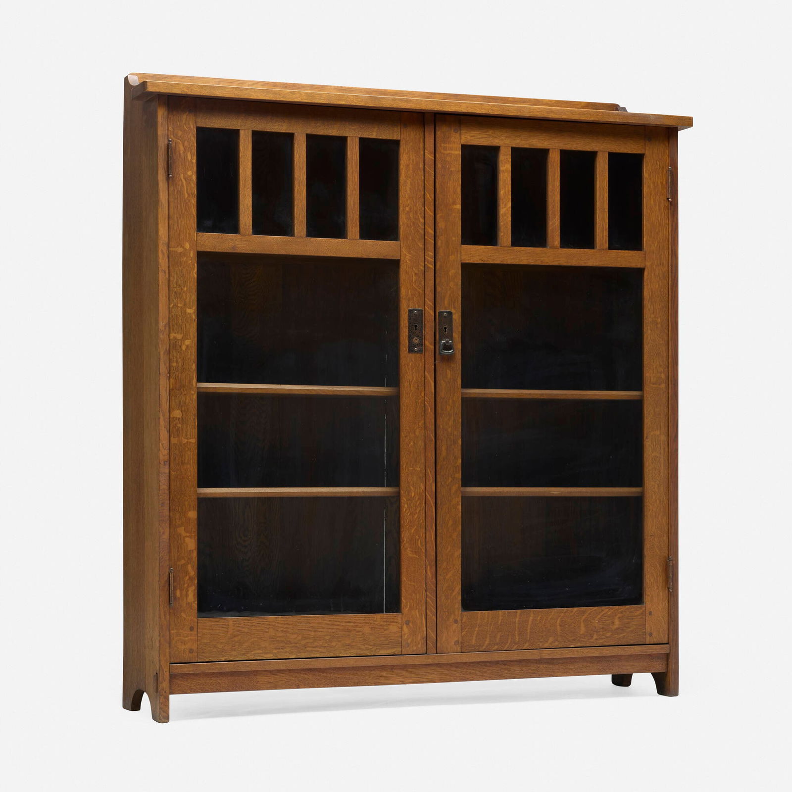 L. & J.G. Stickley, Bookcase, model 654: L. & J.G. Stickley Bookcase, model 654 USA, c. 1912-17 oak, brass, glass 55 h x 50 w x 12 d in (140 x 127 x 30 cm) Cabinet features two doors concealing one fixed and two adjustable shelves.