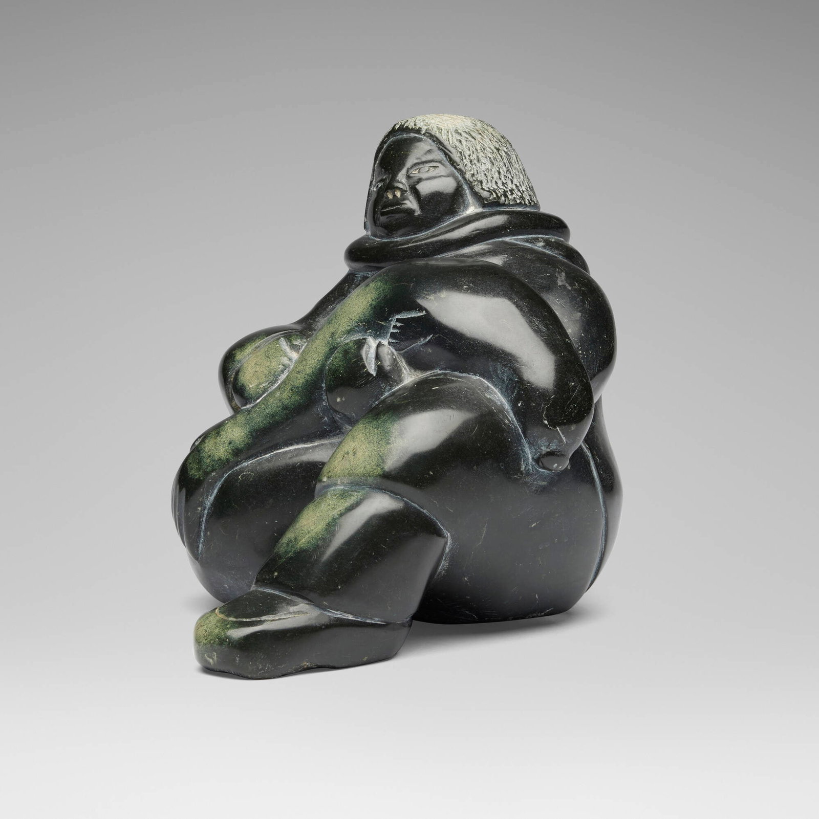 Manome Sago, Sitting Inuit Figure with Seal: Manome Sago Sitting Inuit Figure with Seal serpentine 7.375 h x 9 w x 6.875 d in (19 x 23 x 17 cm) Incised signature to underside 'Manome Sago'. Provenance: Property from the Estate of Morton