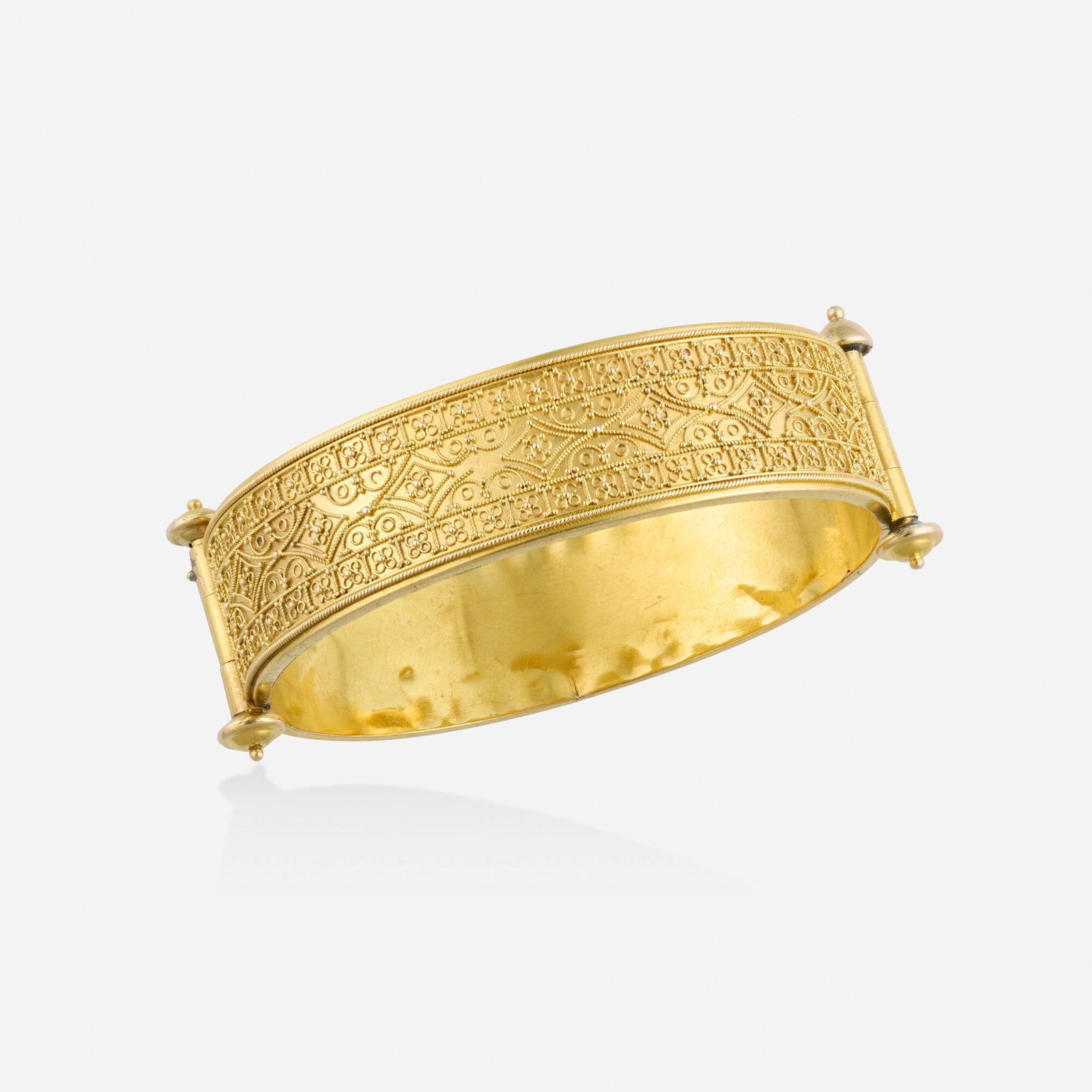 Etruscan Revival, Gold bracelet: Etruscan Revival Gold bracelet The hinged bangle of gold granulation and wirework Yellow gold Inner circ. 6.50 in, width 1 in; Gross weight 15.3 dwts This work will ship from Lambertvi