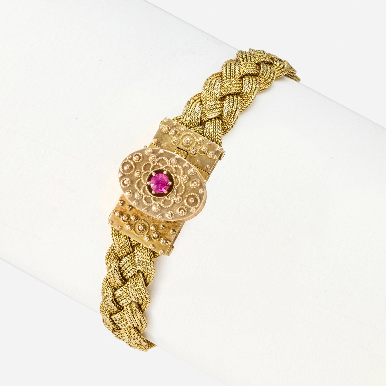 Antique, Synthetic ruby and gold bracelet: Antique Synthetic ruby and gold bracelet Designed with a woven gold bracelet, the locket clasp of gold granulation and wirework, set with a circular-cut synthetic ruby 14k yellow gold Inner circ. 7 in