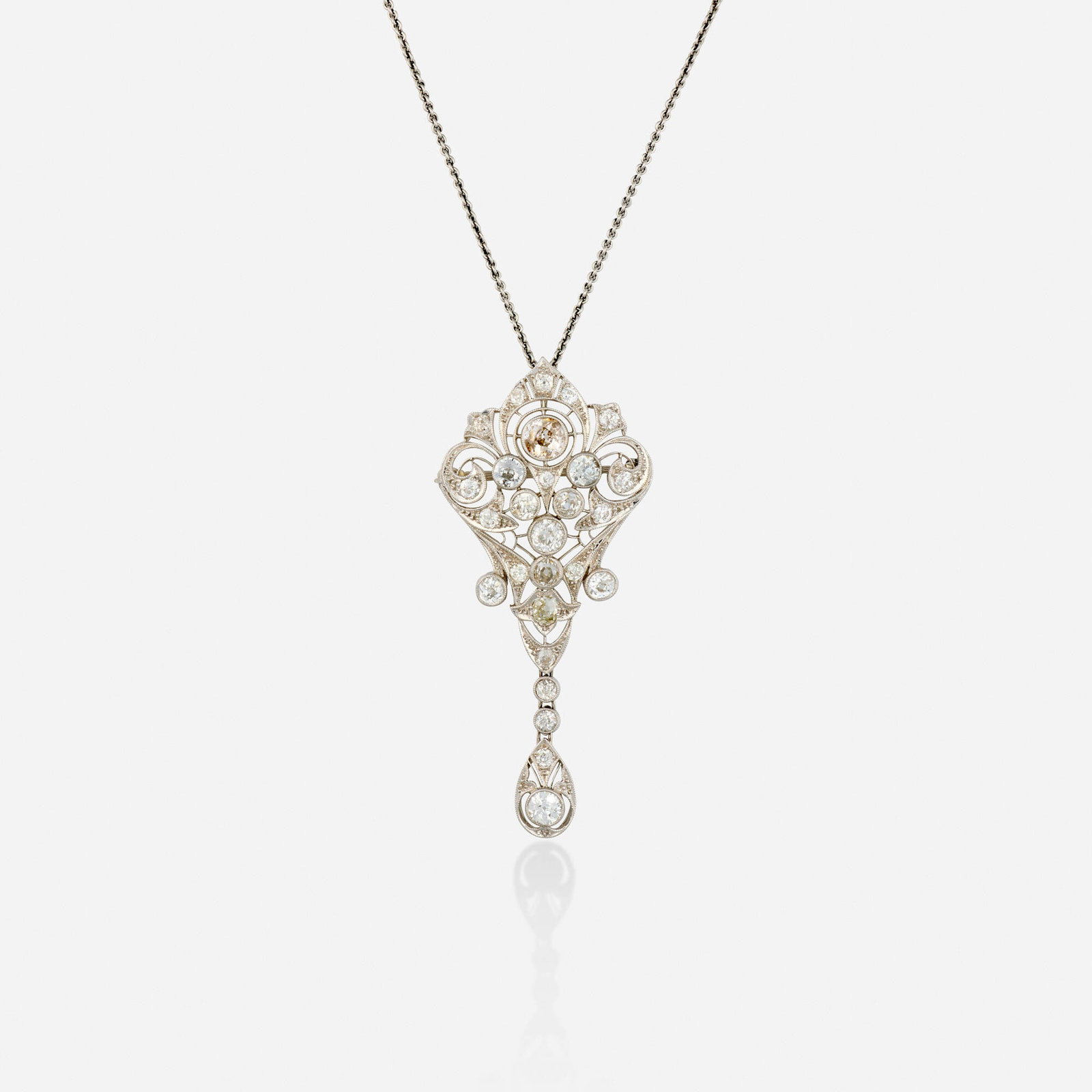 Edwardian, Diamond and platinum pendant brooch with chain: Edwardian Diamond and platinum pendant brooch with chain The pendant brooch of scrolling design, set with old mine and old European-cut diamonds, suspended from the fine link chain Platinum Necklace 1