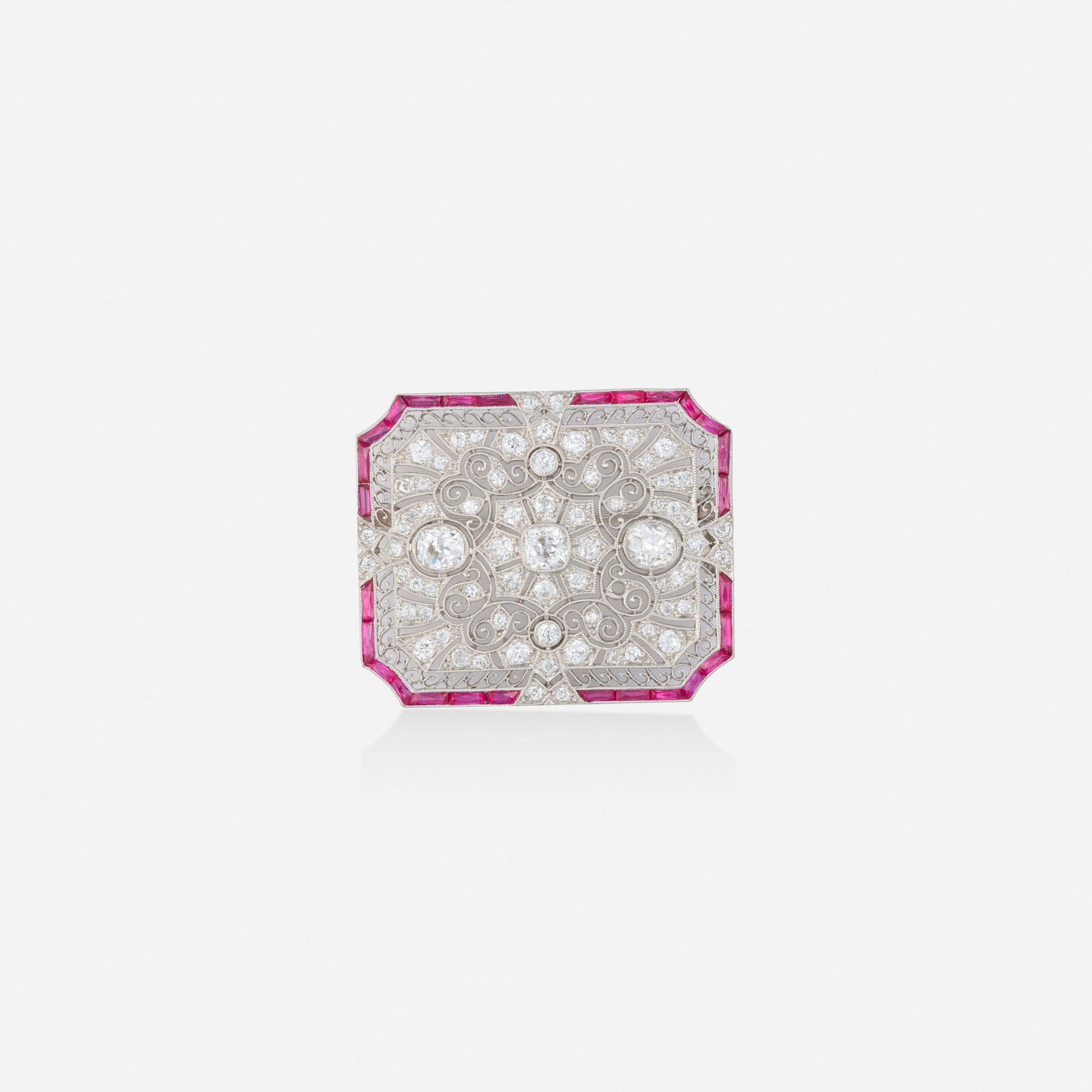 Art Deco, Synthetic ruby, diamond, and platinum pendant brooch: Art Deco Synthetic ruby, diamond, and platinum pendant brooch Of pierced design, set with calibre-cut synthetic rubies, old mine and single-cut diamonds Platinum 1.375 x 1.125 in; Gross weight 9.3 dwt
