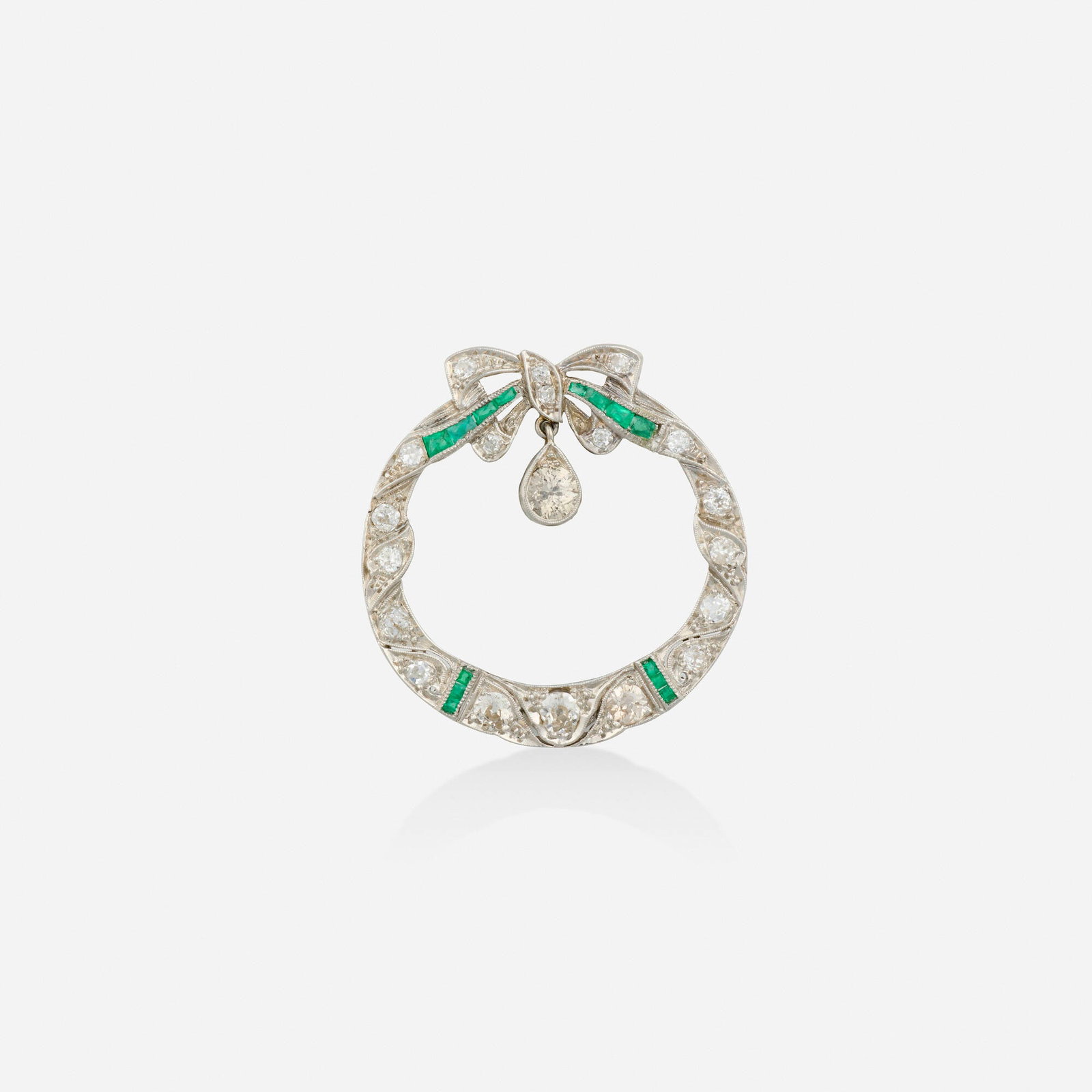 Kobrin Bros., Art Deco diamond, emerald, and platinum brooch: Kobrin Bros. Art Deco diamond, emerald, and platinum brooch Designed as a wreath and bow, set with calibre-cut emeralds, old European and old mine-cut diamonds Platinum Signed Kobrin Bros. 1.375 x