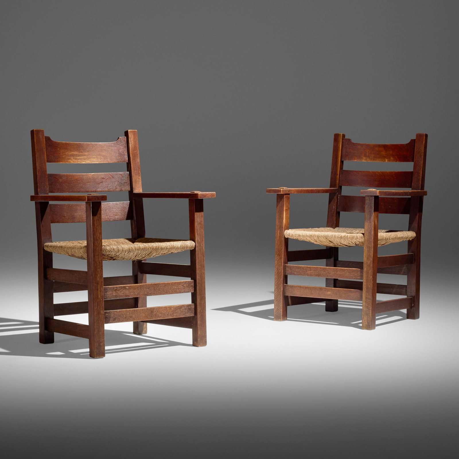 Gustav Stickley, Early U-back armchairs model 2616, pair: Gustav Stickley Early U-back armchairs model 2616, pair USA, c. 1902 oak, rush 38.75 h x 26 w x 23.5 d in (98 x 66 x 60 cm) Red manufacturer's decal to underside of each example 'Als