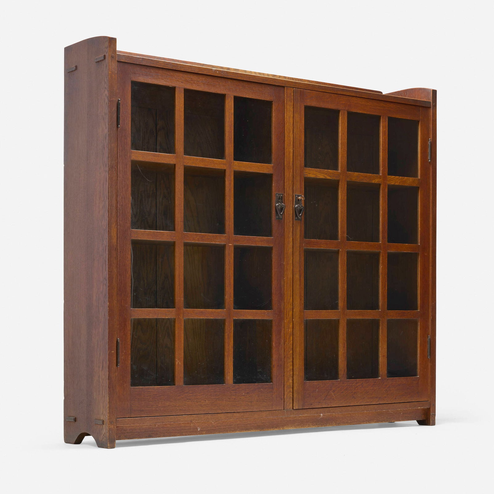 Gustav Stickley, Bookcase, model 719: Gustav Stickley Bookcase, model 719 USA, c. 1907 oak, glass, iron 56 h x 60 w x 13 d in (142 x 152 x 33 cm) Bookcase features two doors concealing six fixed shelves. Red manufacturer's dec