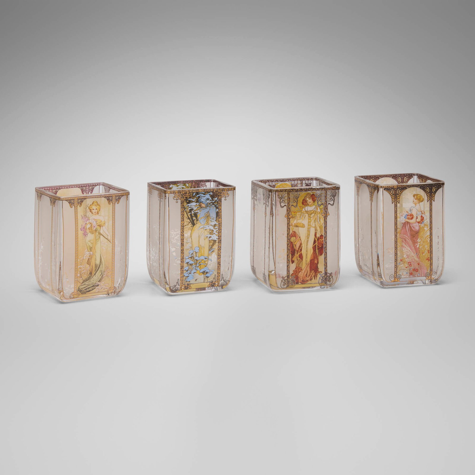 After Alphonse Mucha, 'The Seasons 1900' tea light holders, set of four: After Alphonse Mucha 'The Seasons 1900' tea light holders, set of four from the Artis Orbis collection Goebel Germany, 21st century gilt and transfer-printed hand-blown glass 4 h x 2.75 w x 2.75 d in
