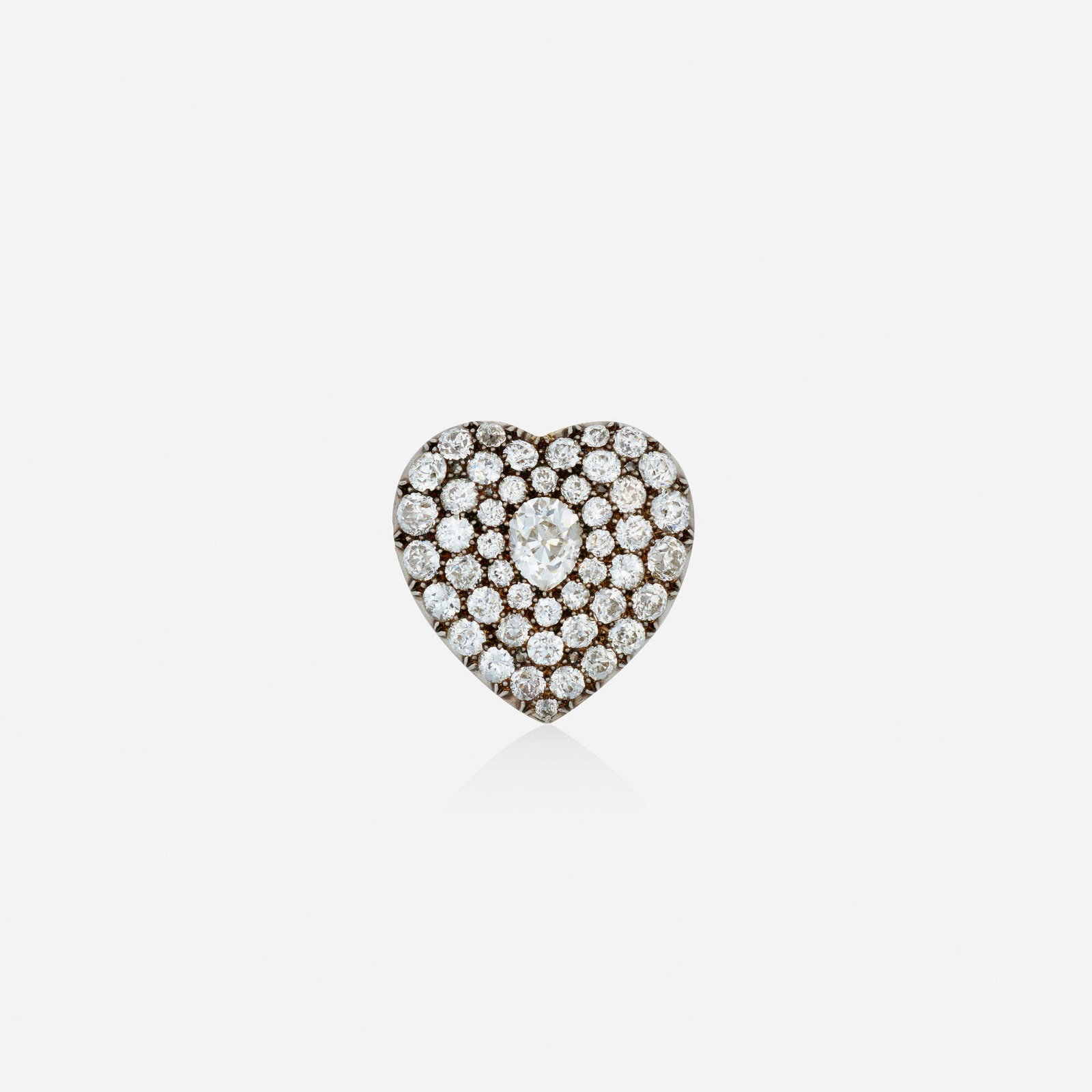 Antique, Diamond and silver-topped gold brooch: Antique Diamond and silver-topped gold brooch The heart centered on a pear-shaped diamond, surrounded by old European-cut diamonds Silver-topped yellow gold 1 x 1 in; Gross weight 4.8 dwts Sold with a