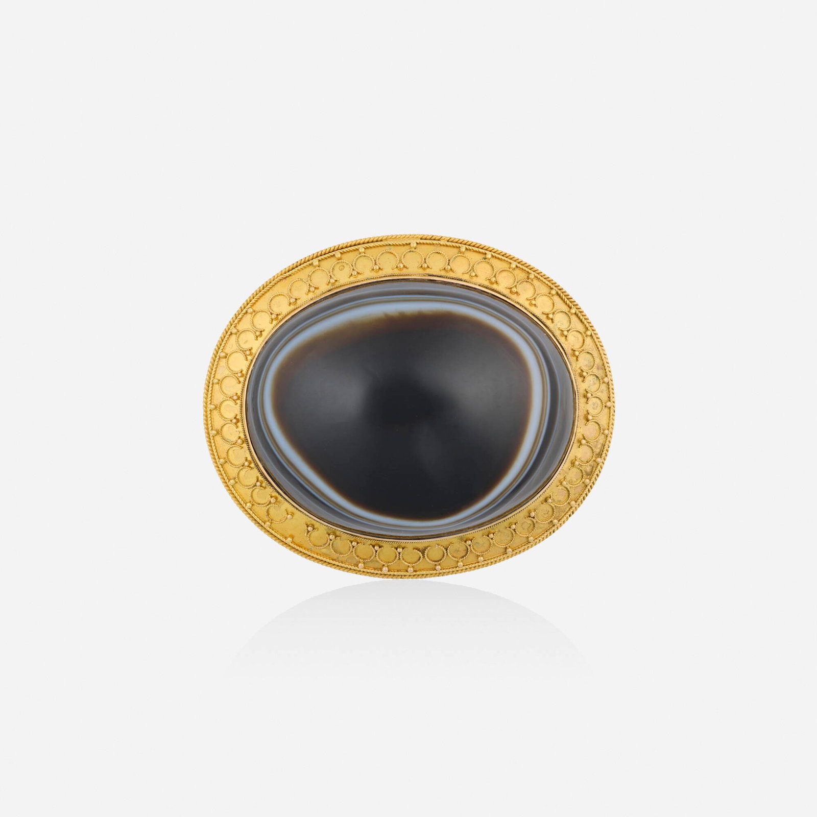 Etruscan Revival, Agate and gold brooch: Etruscan Revival Agate and gold brooch Set with a cabochon banded agate, framed with granulation and wirework Yellow gold 2.125 x 1.75 in; Gross weight 24.3 dwts This work will ship from Lambertville,