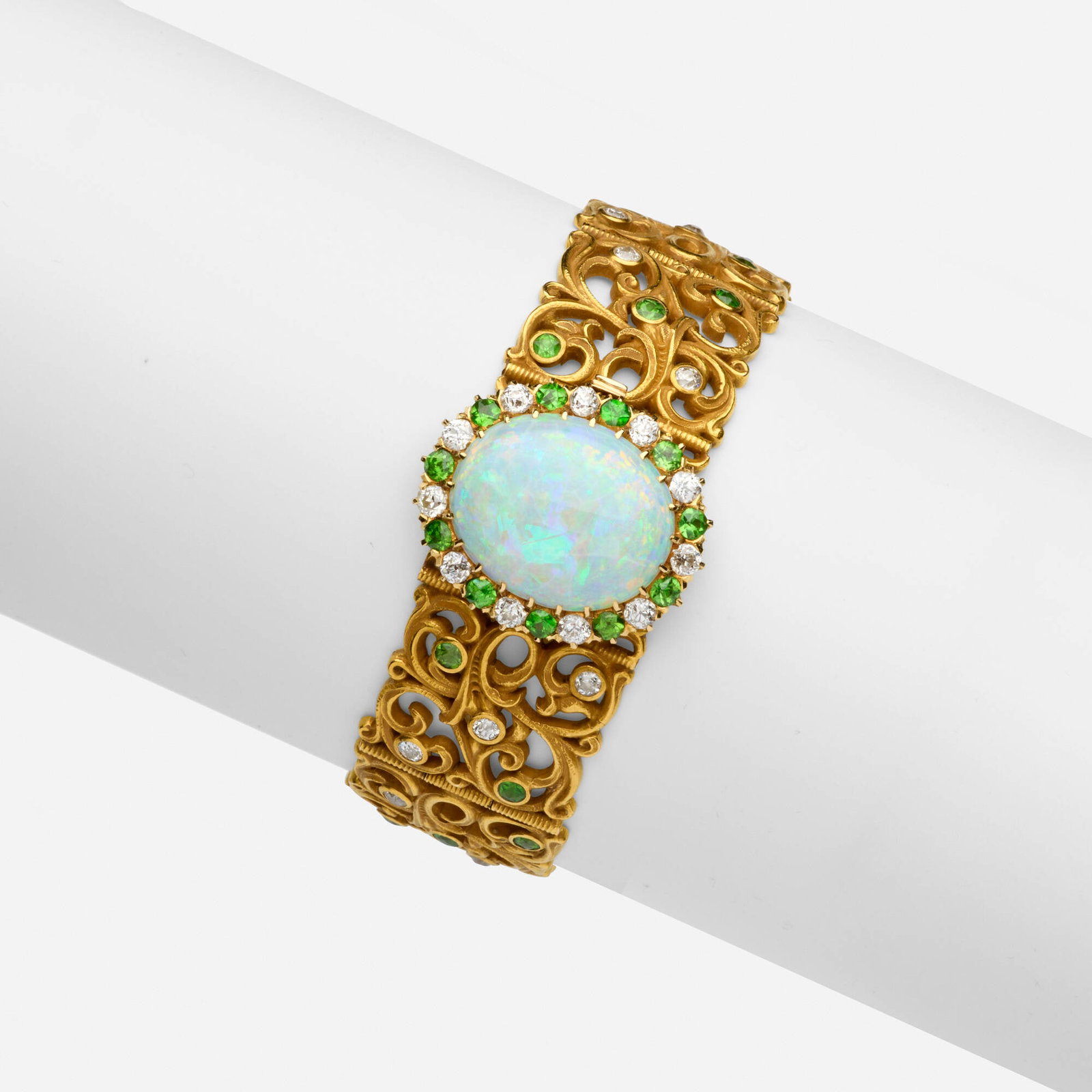Gustav Manz, Art Nouveau opal, demantoid garnet, and diamond bracelet: Gustav Manz Art Nouveau opal, demantoid garnet, and diamond bracelet Of filigree design, set with a cabochon opal, circular-cut demantoid garnets, and old mine-cut diamonds Yellow gold 6.875 x 0.875 i