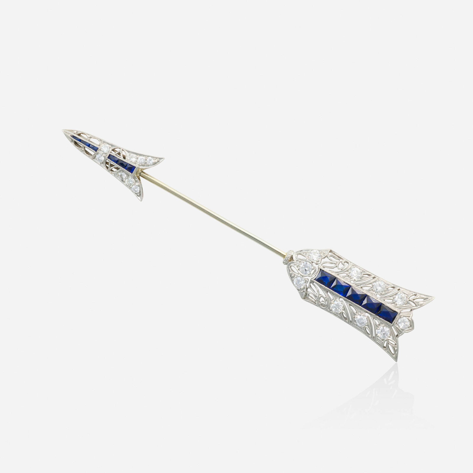 Art Deco, Diamond, glass, and platinum jabot pin: Art Deco Diamond, glass, and platinum jabot pin Designed as an arrow set with old European-cut diamonds and French-cut blue glass Platinum 3.625 x 0.625 in; Gross weight 6.4 dwts This work will ship f