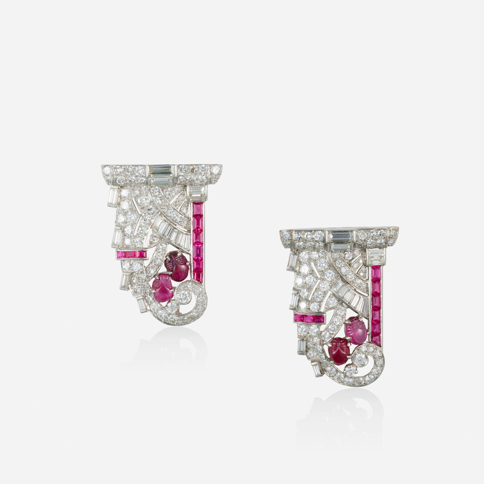 Art Deco, Two synthetic ruby, ruby, and diamond dress clips: Art Deco Two synthetic ruby, ruby, and diamond dress clips Each of geometric design, set with carved rubies, rectangular-cut synthetic rubies, and old European, round brilliant, baguette, and single-c
