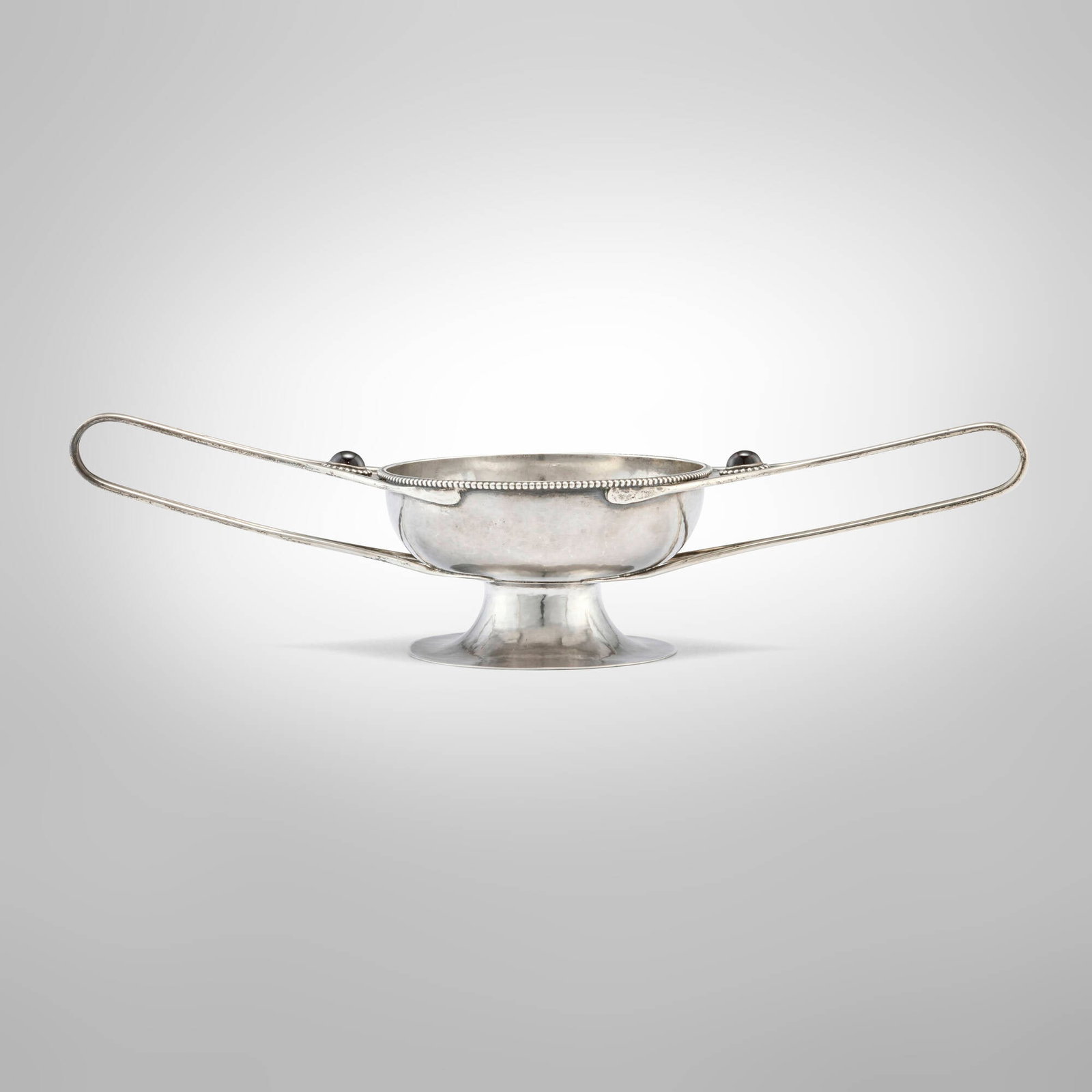 Marcus & Co., Arts & Crafts two-handled dish: Marcus & Co. Arts & Crafts two-handled dish USA, 1907-12 sterling silver, garnet 3 h x 12.75 w x 4.375 d in (8 x 32 x 11 cm) The present work by the New York firm Marcus & Co. was inspired by a Charle