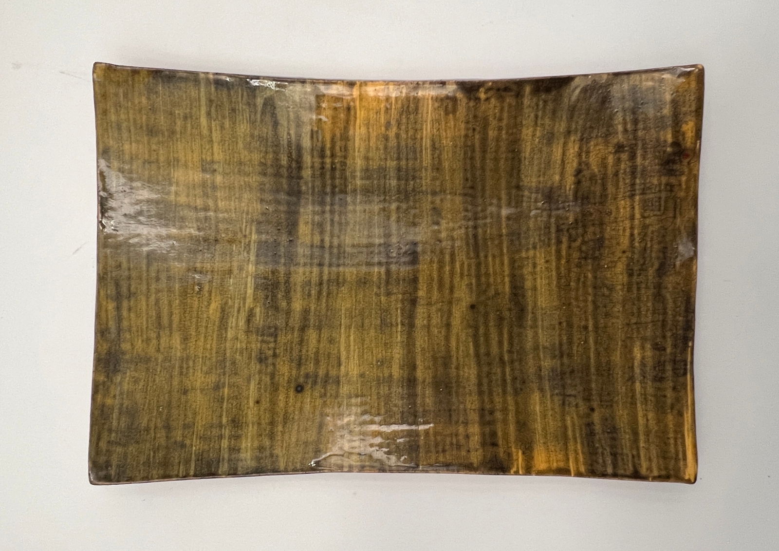 Toshiko Takaezu plate: Fig Green glazed ceramic plate, some yellow color touch on the surface of the plate, Signed on the back