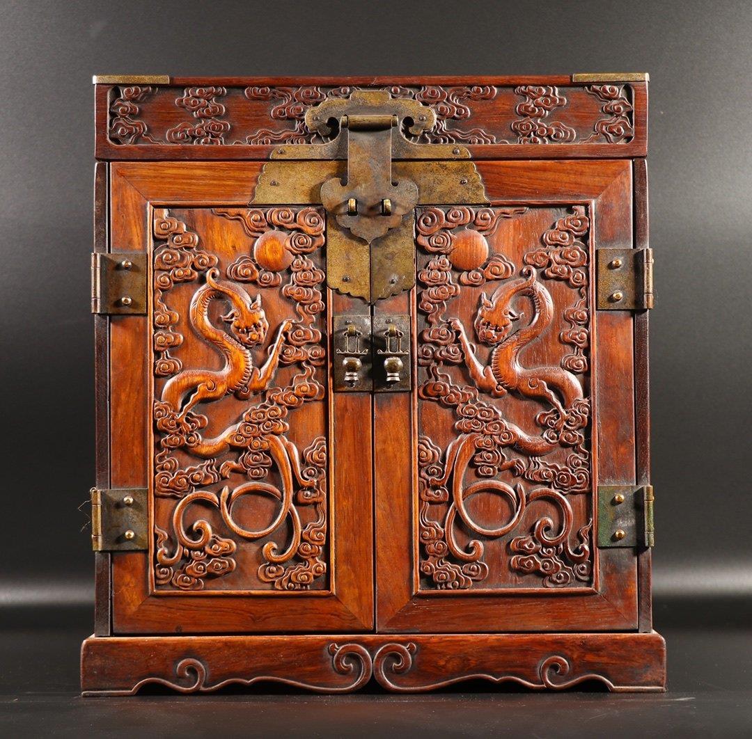 A HUANGHUALI WOOD CARVING 'DRAGON' CABINET: A huanghuali wood carving 'dragon' cabinet. Probably made in the Chinese Qing Dynasty Period. Dimension: H 41 cm, W 36.5 cm, D 28 cm. All measurements are approximate.