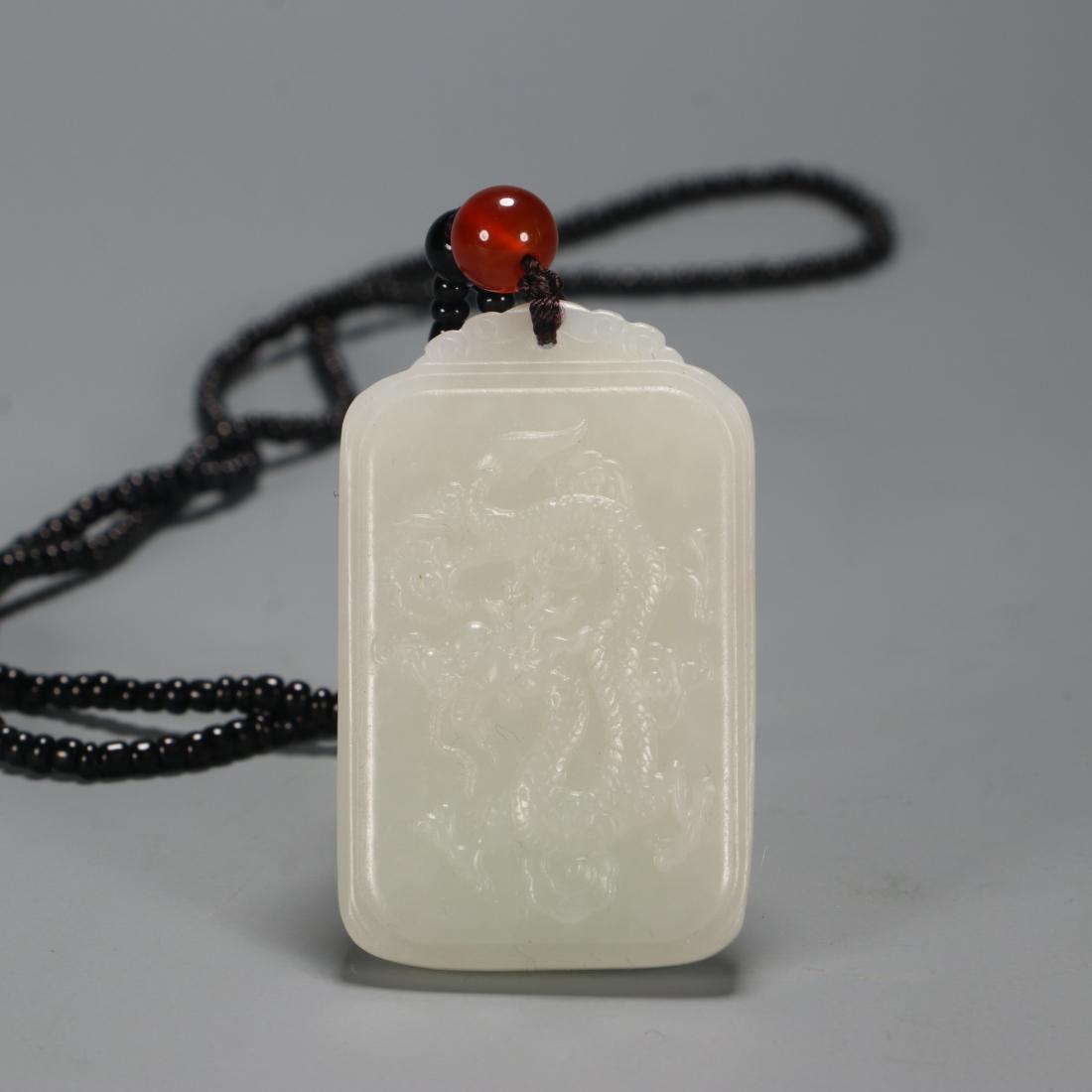 JADE CARVING 'DRAGON & CRANE' HANGING PLAQUE: Jade carving 'dragon & crane' hanging plaque. Dimensions: H 5 cm, W 3.1 cm, D 0.6 cm, Weight 30 g. All measurements are approximate.