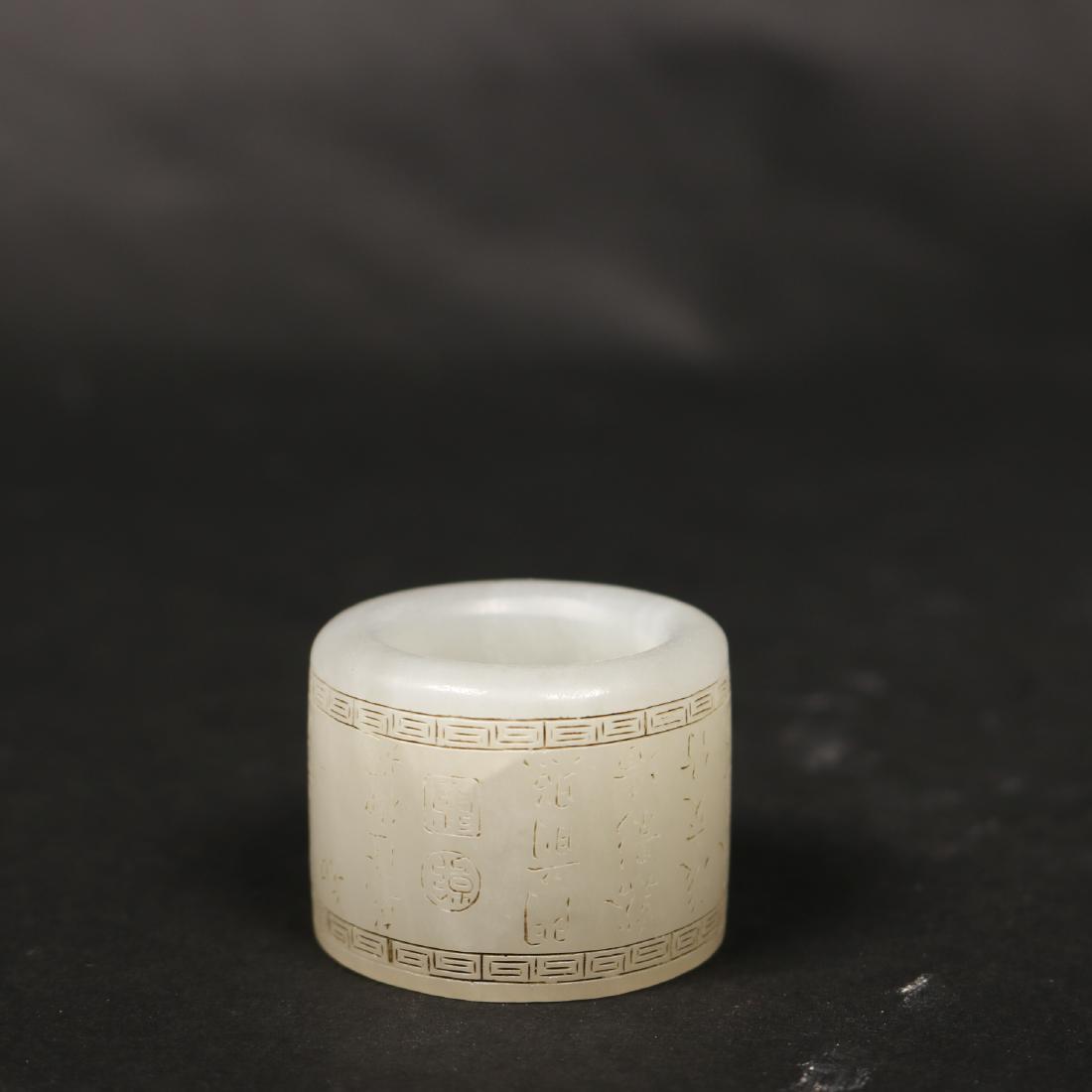 A Imperial White Jade Poems Thumb Ring: A Chinese white jade thumb ring with carved poems and Qianlong seal. Qing dynasty or late.Size: 1 3/4 inches hight,1 1/2 Diameter.Provenance:Acquired from Professor Alex,a private collection in Orange