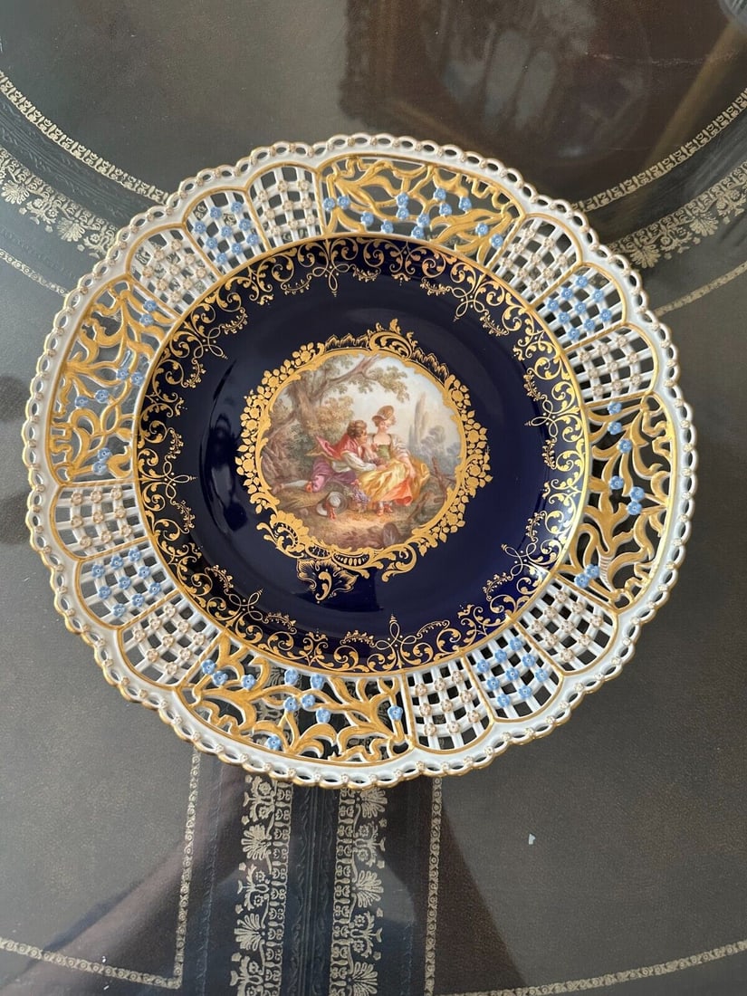 ANTIQUE MEISSEN PORCELAIN COBALT-BLUE GROUND RETICULATED CABINET PLATE: ANTIQUE MEISSEN PORCELAIN COBALT-BLUE GROUND RETICULATED CABINET PLATE. LATE 19TH CENTURY, BLUE CROSSED SWORDS MARKS, VARIOUS IMPRESSED NUMERALS. Finely painted Watteau scene 103/8 in. (26.3 cm.) diam