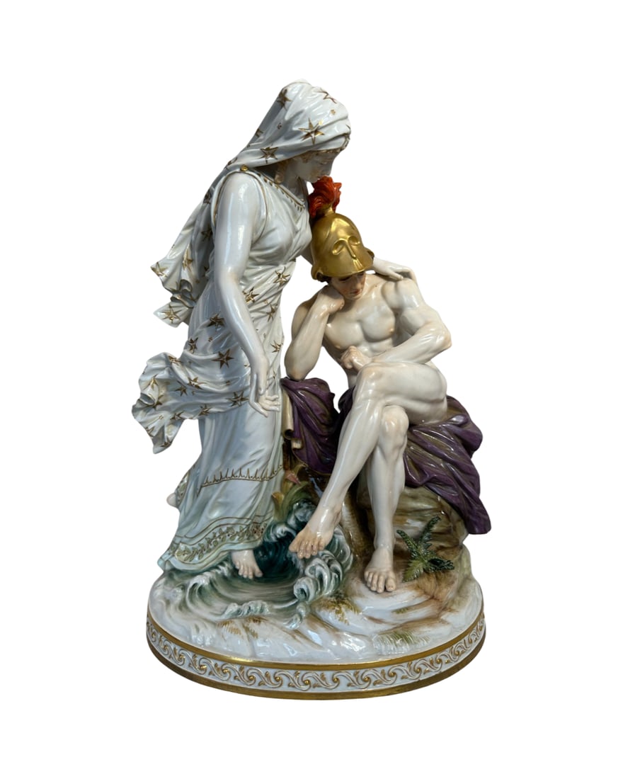 Meissen Porcelain Mythological Figural Group of Achilles and Thetis: The Trojan War hero modeled seated on a rocky mound with his legs crossed, in the nude, with a plumed golden helmet, his mother, Thetis, modeled standing beside him in a comforting stance, oval base, 