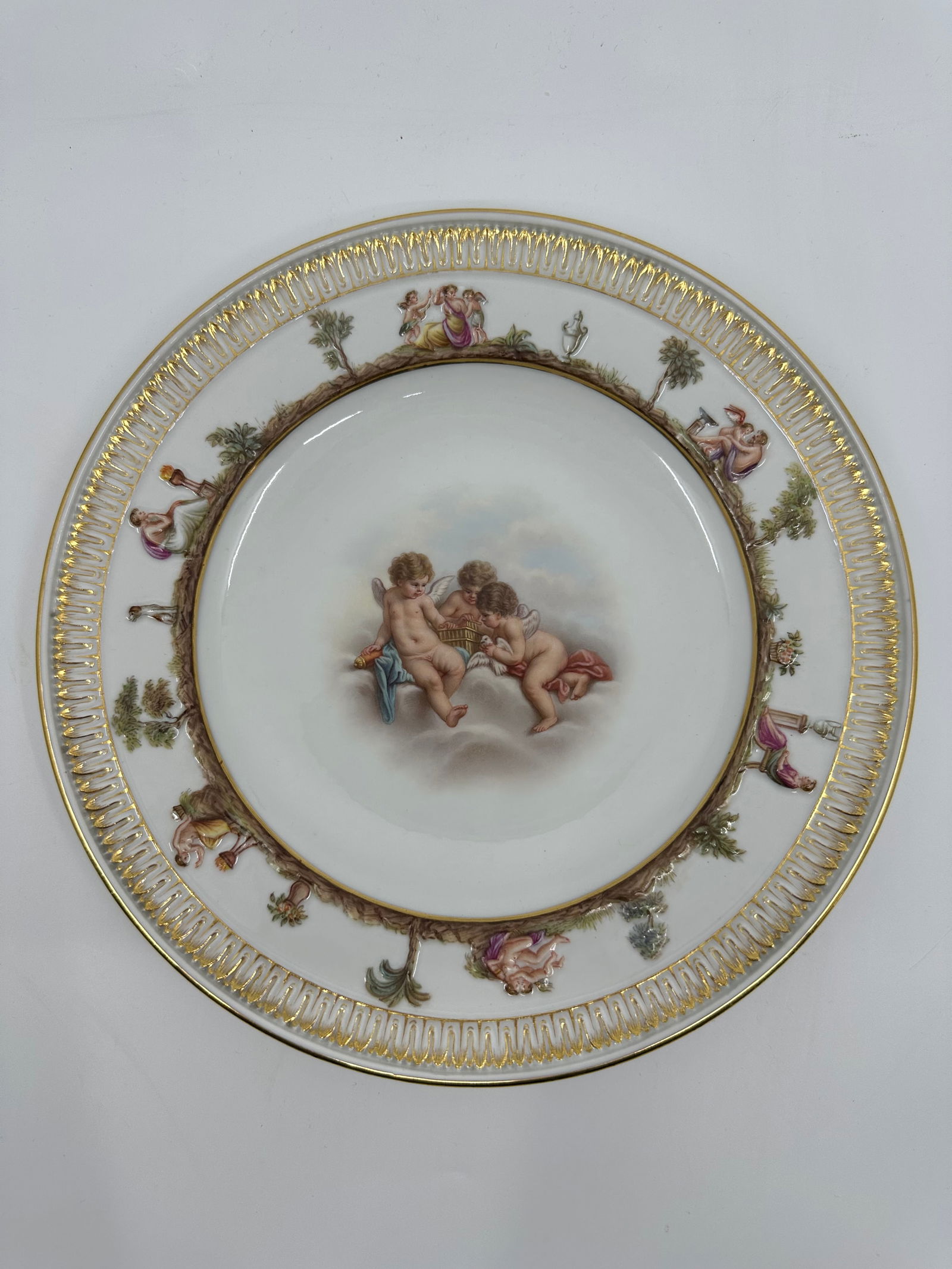 ANTIQUE MEISSEN PORCELAIN CAPODIMONTE PLATE: ANTIQUE MEISSEN PORCELAIN CAPODIMONTE PLATE LATE 19TH, BLUE CROSSED SWORDS MARK, IMPRESSED 44 Finely painted a putto scenes, the border molded with Capodimonte style mythological views and a band of s