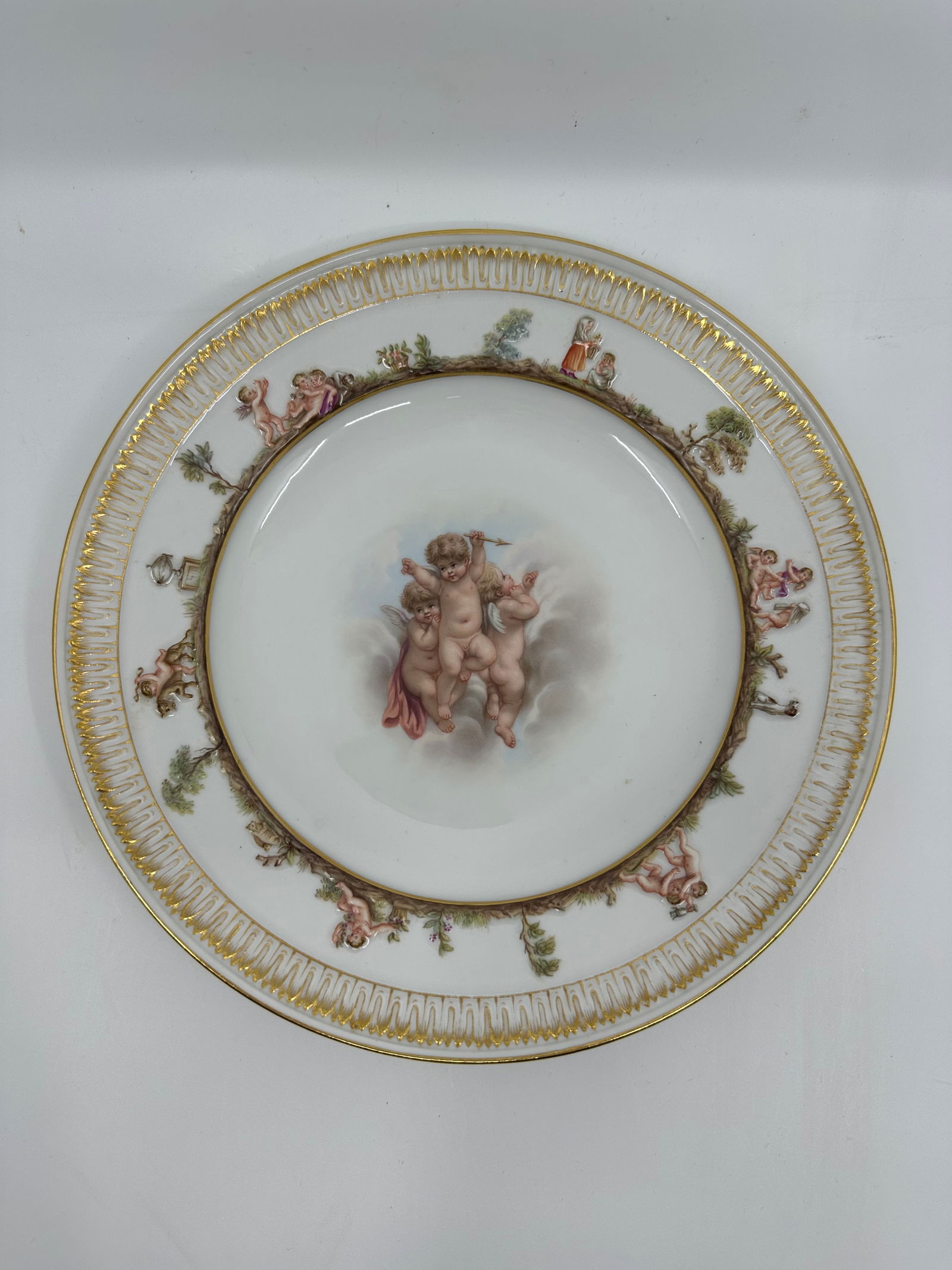 ANTIQUE MEISSEN PORCELAIN CAPODIMONTE PLATE: ANTIQUE MEISSEN PORCELAIN CAPODIMONTE PLATE LATE 19TH, BLUE CROSSED SWORDS MARK, IMPRESSED 44 Finely painted a putto scenes, the border molded with Capodimonte style mythological views and a band of s