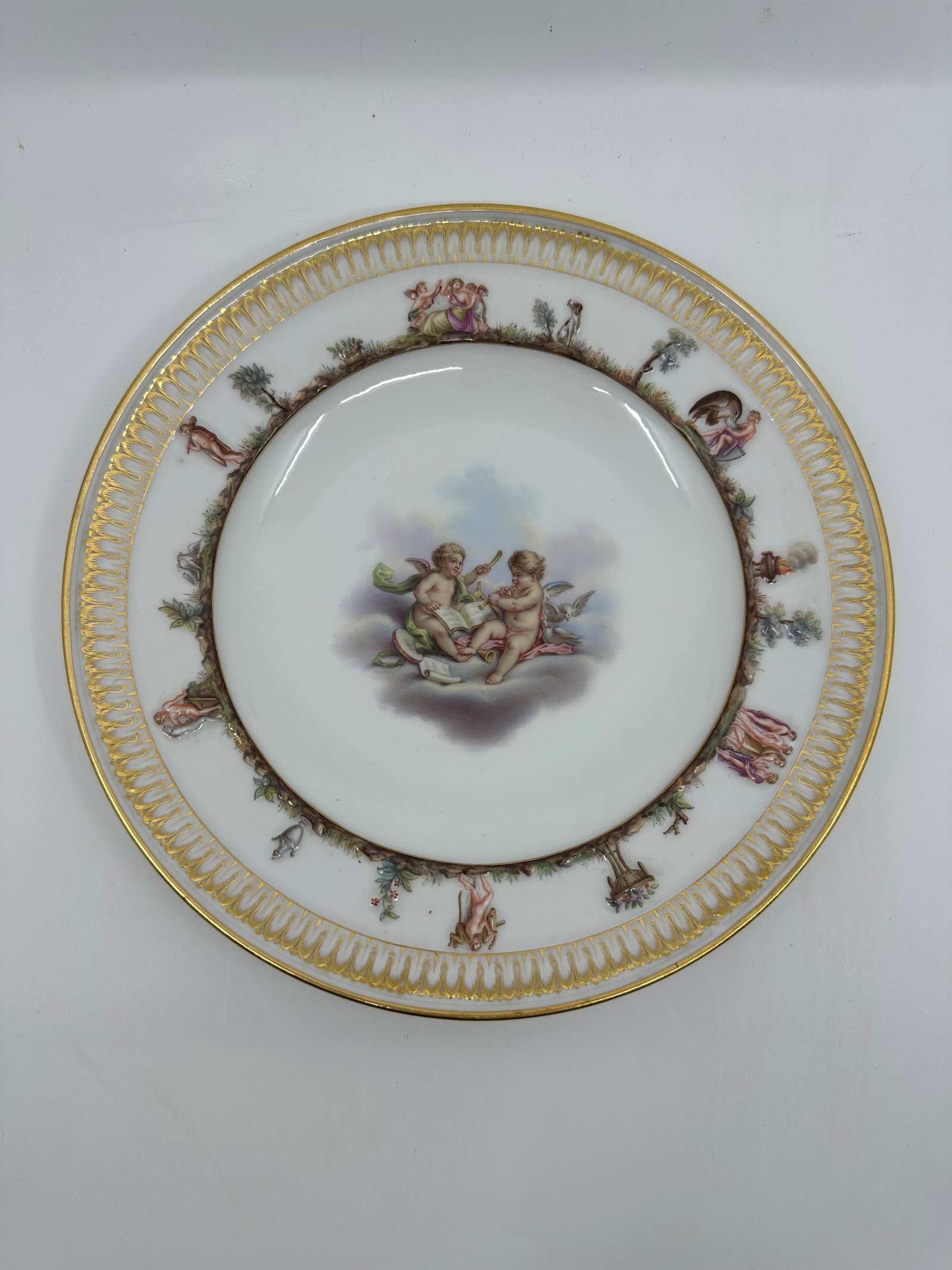 ANTIQUE MEISSEN PORCELAIN CAPODIMONTE PLATE: ANTIQUE MEISSEN PORCELAIN CAPODIMONTE PLATE LATE 19TH, BLUE CROSSED SWORDS MARK, IMPRESSED 44 Finely painted a putto scenes, the border molded with Capodimonte style mythological views and a band of s