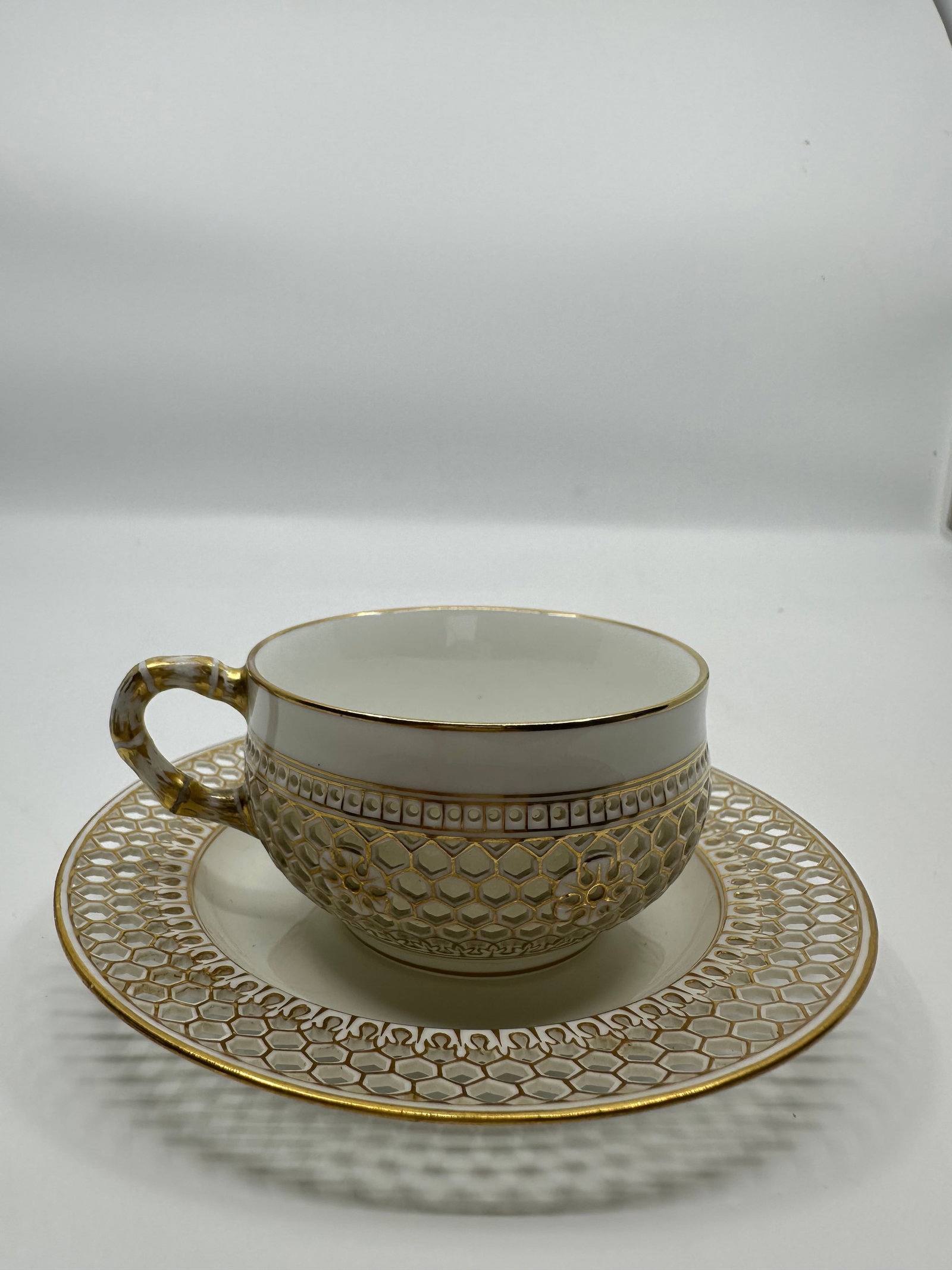 FINE 19th C SEVRES RETICULATED CUP AND SAUCER: The cup, doubled walled with pierced outer layer The saucer with similar pierced border. Both with fine hand-painted flowers and gilding. Bearing Sevres' marks for. 1881. French, 19th C. Saucer dia.: 