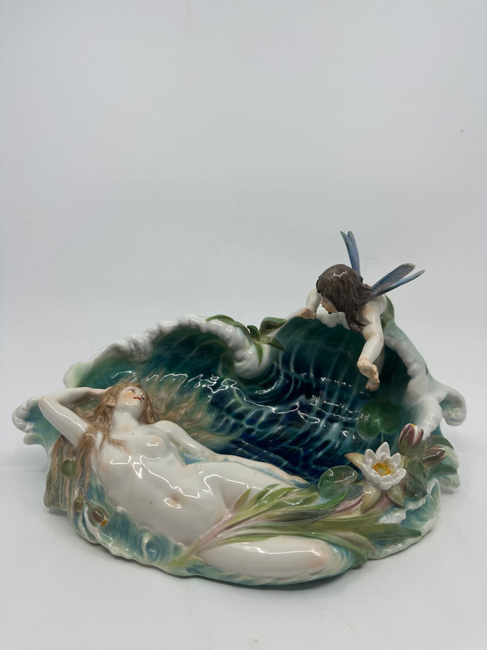 Antique Meissen Art nouveau Nymph on a Wave by Paul Helmig: Description:Meissen dish with a water nymph reaching out to a young woman lying in the water with water lilies covering her feet. first modelled by Paul Helmig c.1898. Illustrated on page 107 of Meiss