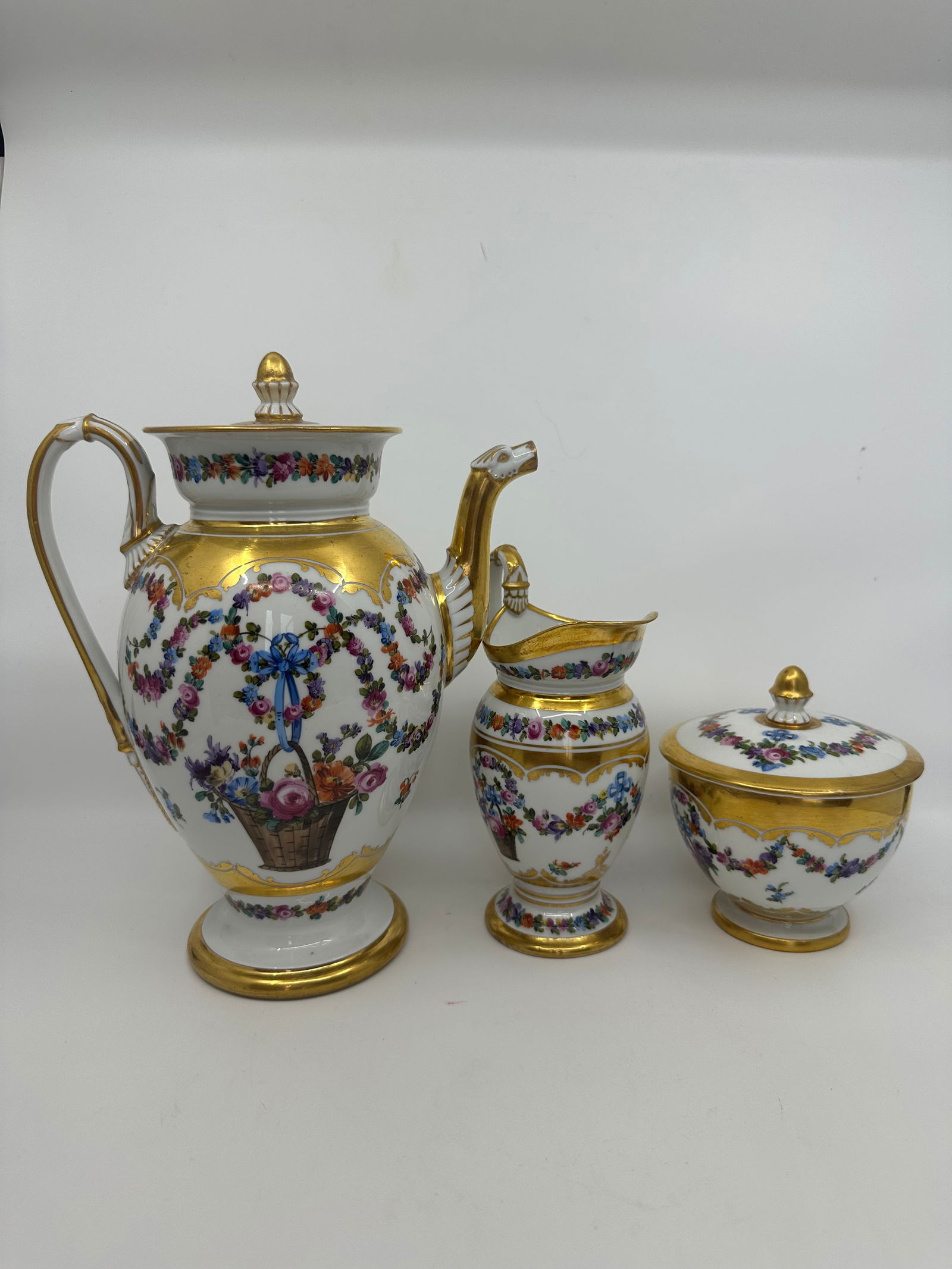 ANTIQUE MEISSEN EMPIRE TEA SET: Description. German, circa 1900, Empire style, includes tea pot, sugar, creamer, richly gilded and with flowers, underglaze blue painted crossed swords with "I" between hilts, items with gilder's mark