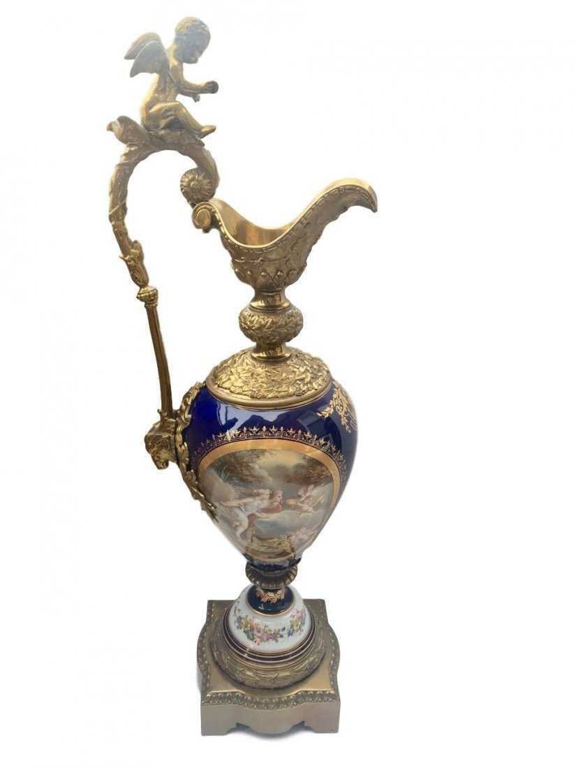 Monumental Antique Sevres Hand Painted Porcelain and Bronze Ewer: ANTIQUE SEVRES ORMOLU-MOUNTED SEVRES COBALT GROUND EWER LATE 19TH Century,Of baluster form with an upright scroll handle, the spout cast with acanthus, the shoulder with stiff-leaf tips, painted front