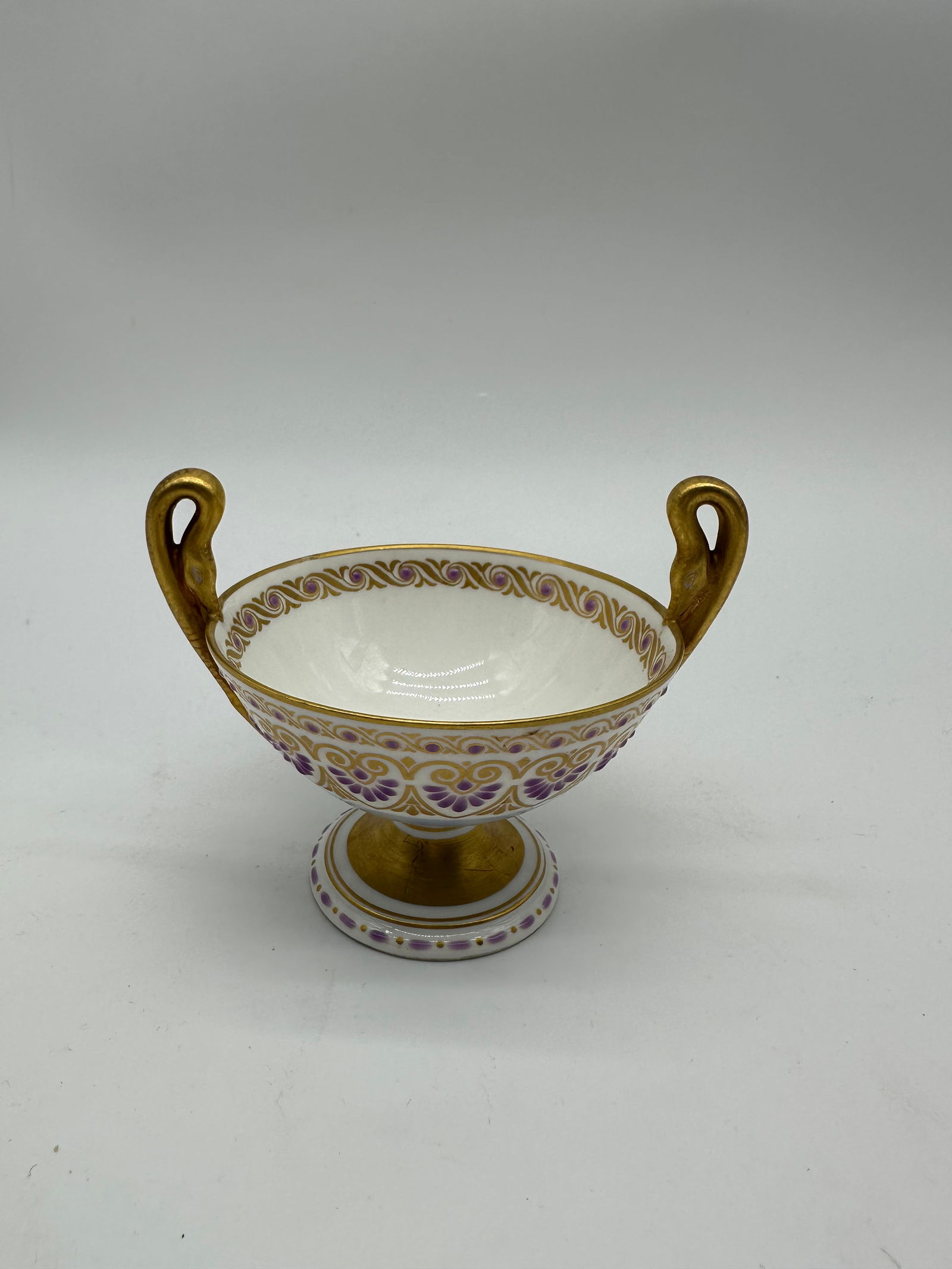 Antique KPM jeweled porcelain goblet: This is a stunning KPM Berlin Porcelain Footed Dish Compote, hand-painted with a delicate floral pattern in shades of purple, accented with rich gold gilt. This piece is a beautiful example of KPM's c